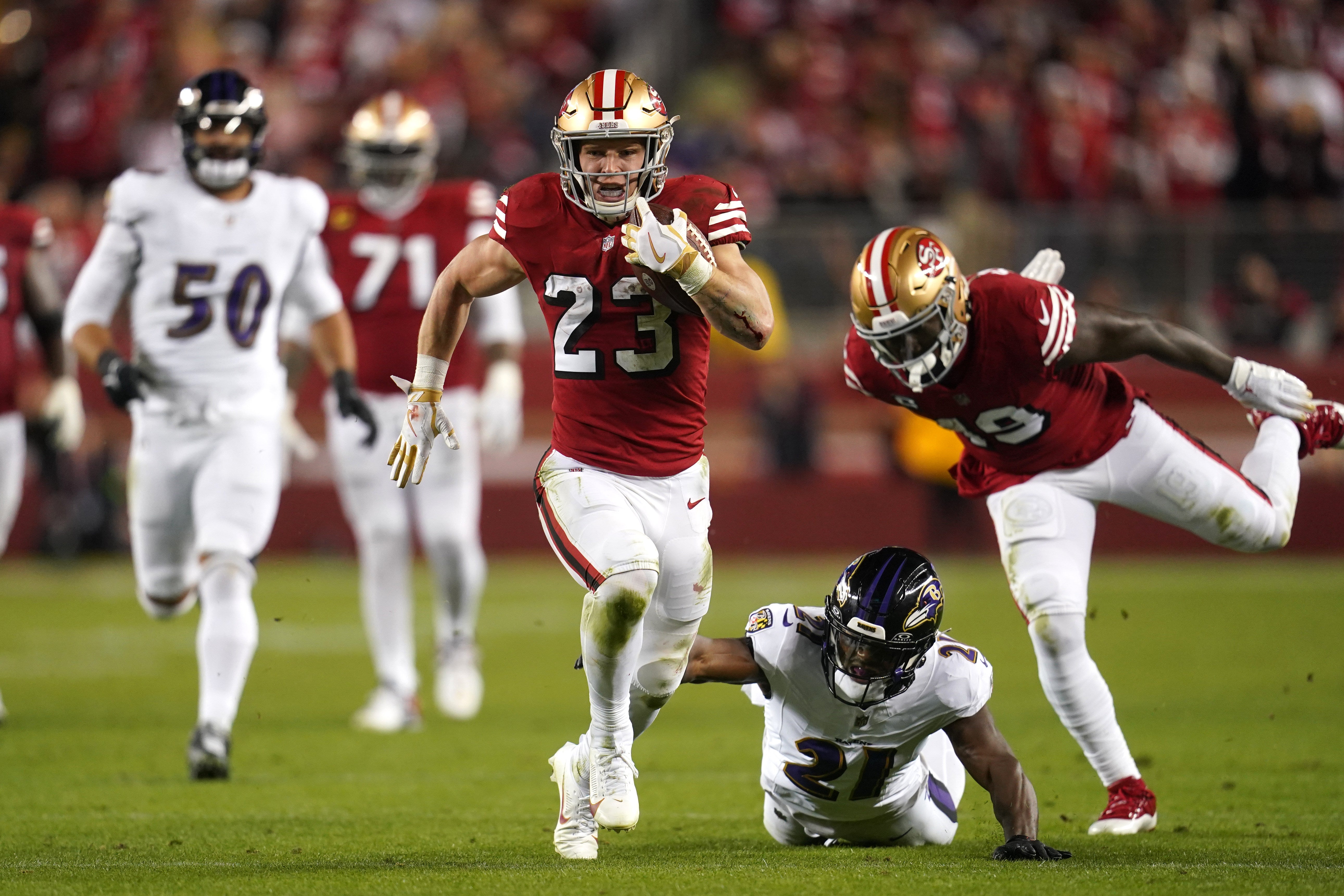 Dec 25, 2023; Santa Clara, California, USA; San Francisco 49ers running back Christian McCaffrey (23) runs the ball pressured by Baltimore Ravens cornerback Brandon Stephens (21) in the second quarter at Levi's Stadium.