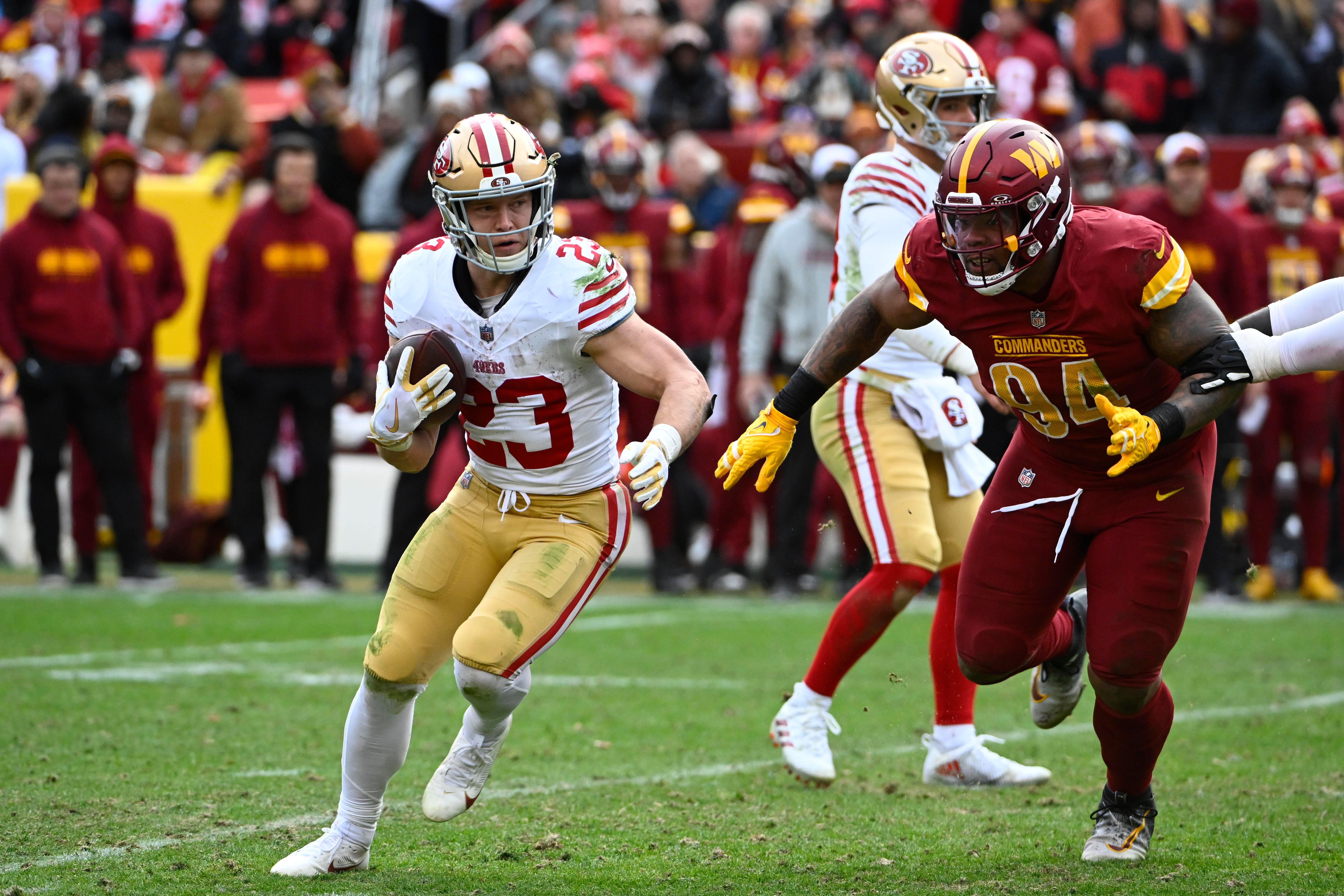 Dec 31, 2023; Landover, Maryland, USA; San Francisco 49ers running back Christian McCaffrey (23) carries the ball as Washington Commanders defensive tackle Daron Payne (94) during the second half at FedExField.