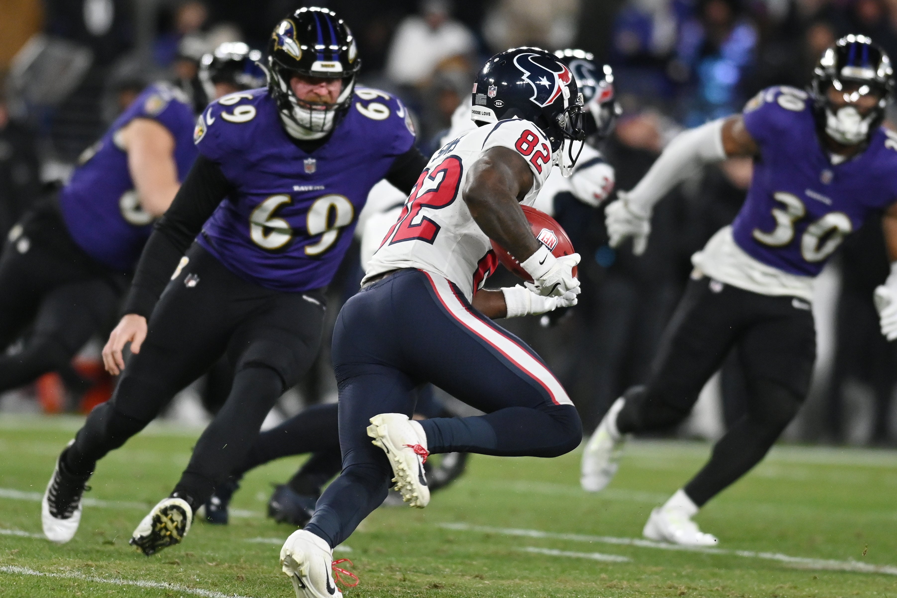 Jan 20, 2024; Baltimore, MD, USA; Houston Texans wide receiver Steven Sims (82) returns a punt for a touchdown against Baltimore Ravens long snapper Tyler Ott (69) and linebacker Trenton Simpson (30) during the second quarter of a 2024 AFC divisional round game at M&T Bank Stadium.