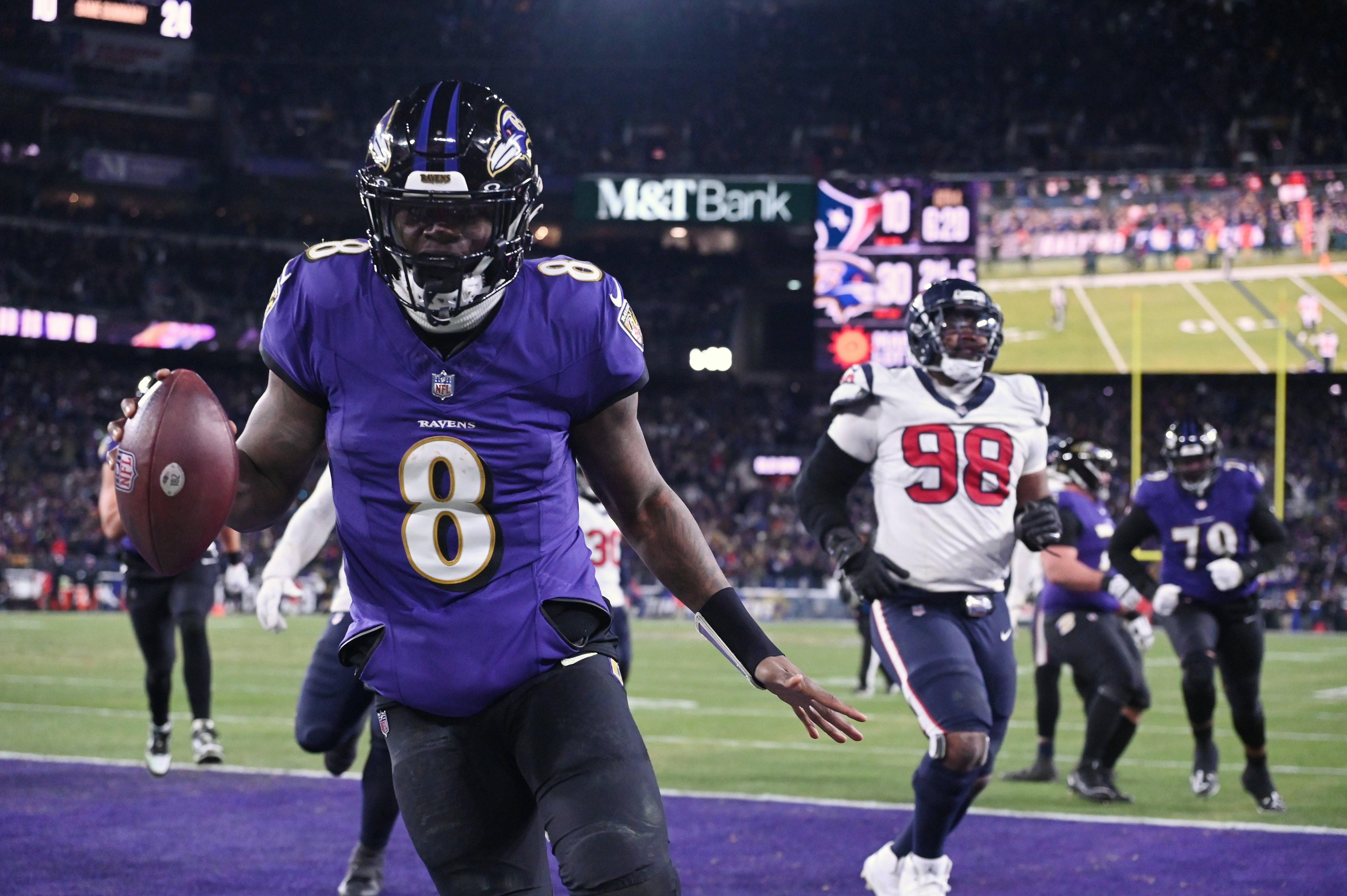 Jan 20, 2024; Baltimore, MD, USA; Baltimore Ravens quarterback Lamar Jackson (8) runs the ball to score a touchdown against Houston Texans defensive tackle Sheldon Rankins (98) during the fourth quarter of a 2024 AFC divisional round game at M&T Bank Stadium.