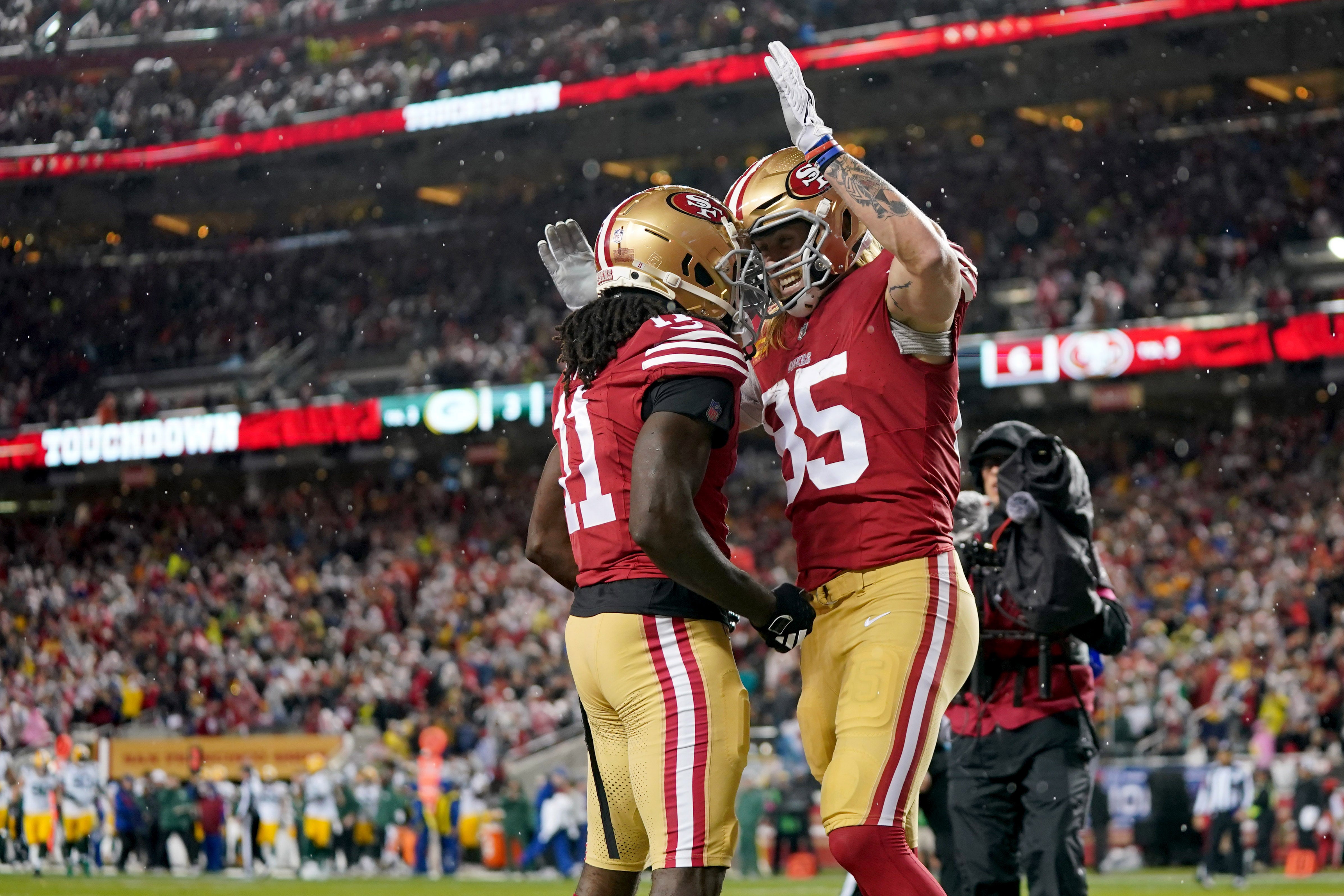 January 20, 2024; Santa Clara, CA, USA; San Francisco 49ers tight end George Kittle (85) celebrates with wide receiver Brandon Aiyuk (11) after scoring a touchdown against the Green Bay Packers during the second quarter in a 2024 NFC divisional round game at Levi's Stadium.