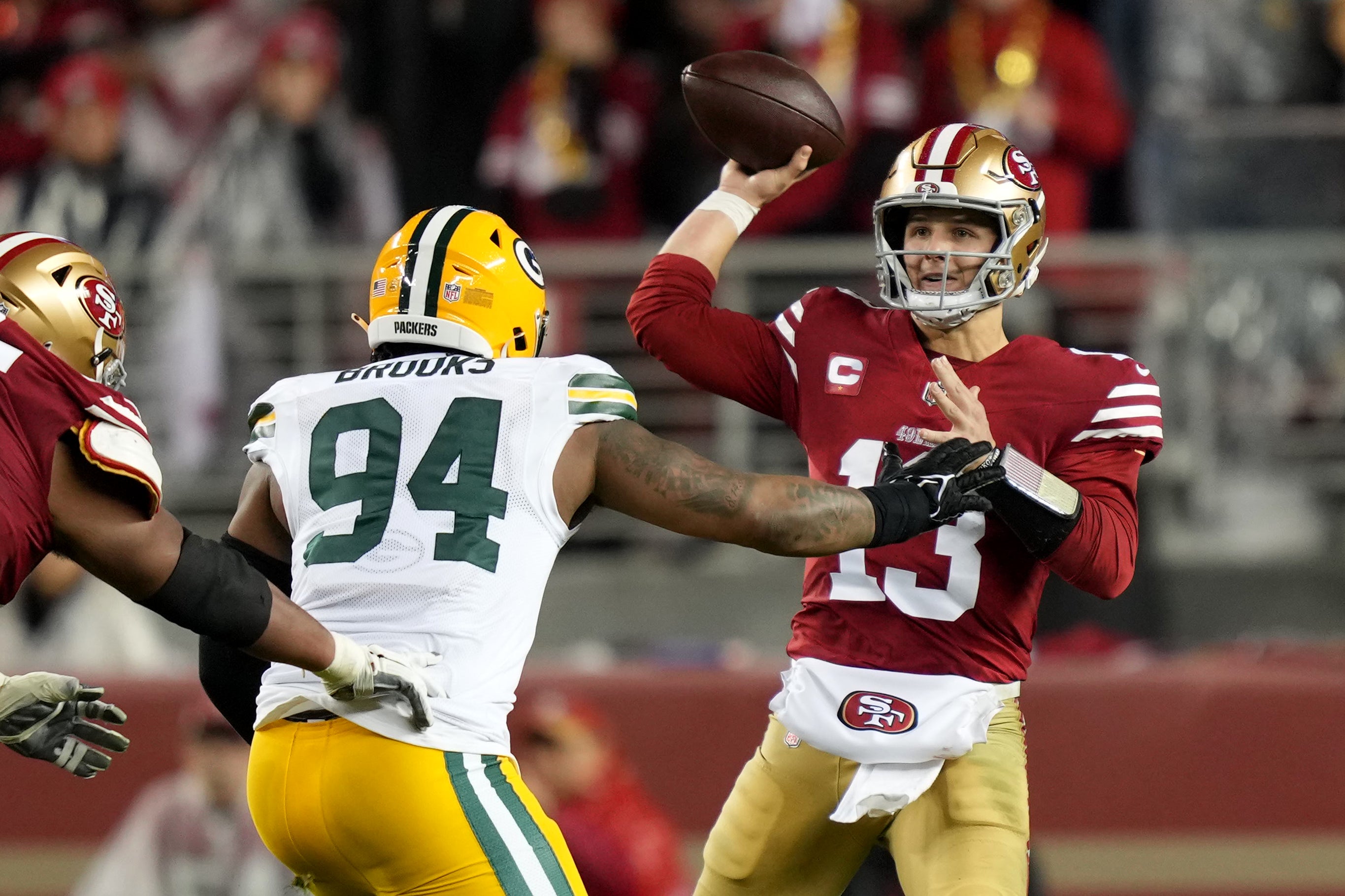 January 20, 2024; Santa Clara, CA, USA; San Francisco 49ers quarterback Brock Purdy (13) passes under pressure from Green Bay Packers defensive end Karl Brooks (94) during the third quarter in a 2024 NFC divisional round game at Levi's Stadium.