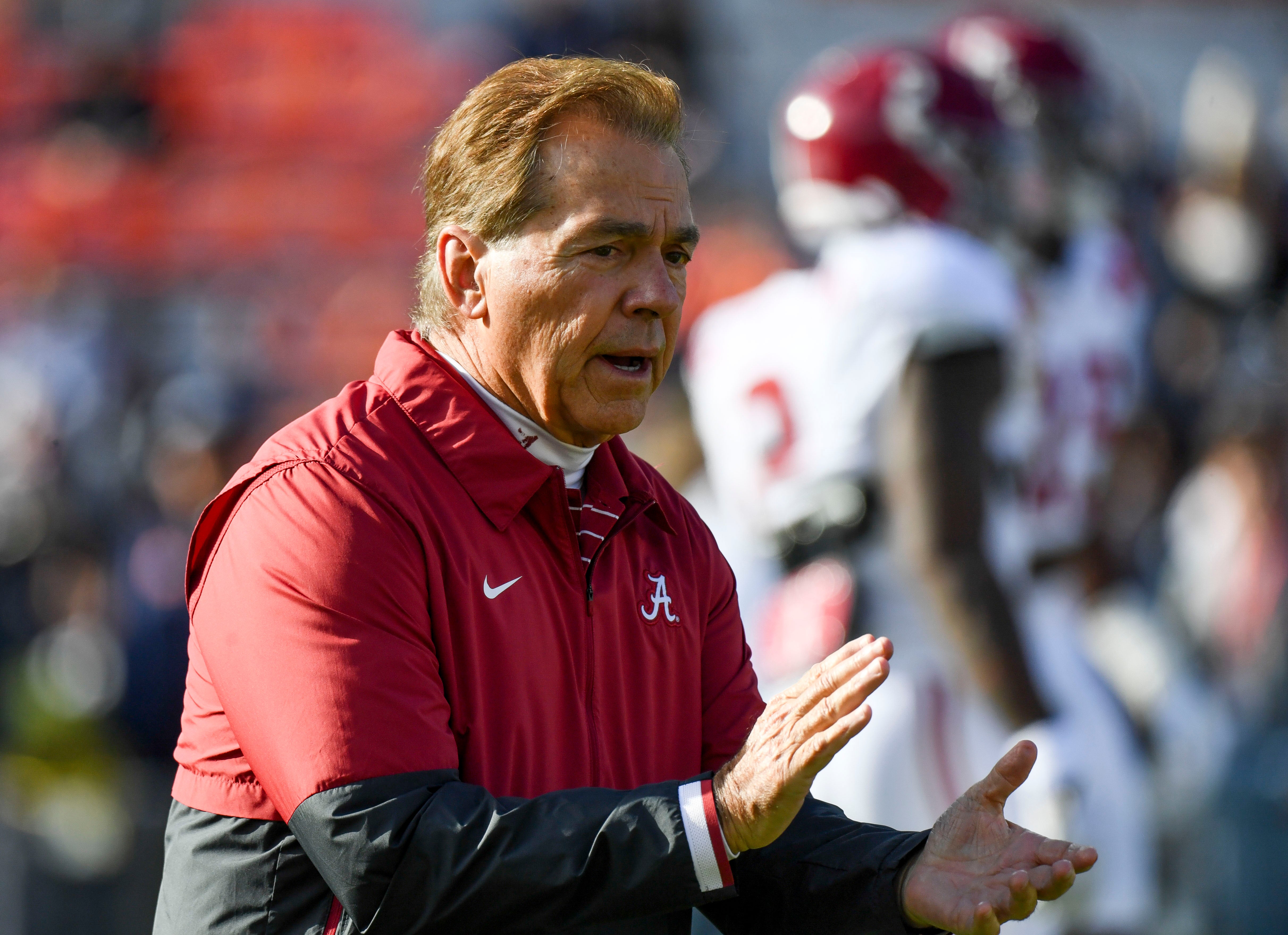 Alabama Crimson Tide head coach Nick Saban encourages Alabama Crimson Tide players as they warm up before the game with the Auburn Tigers at Jordan-Hare Stadium.