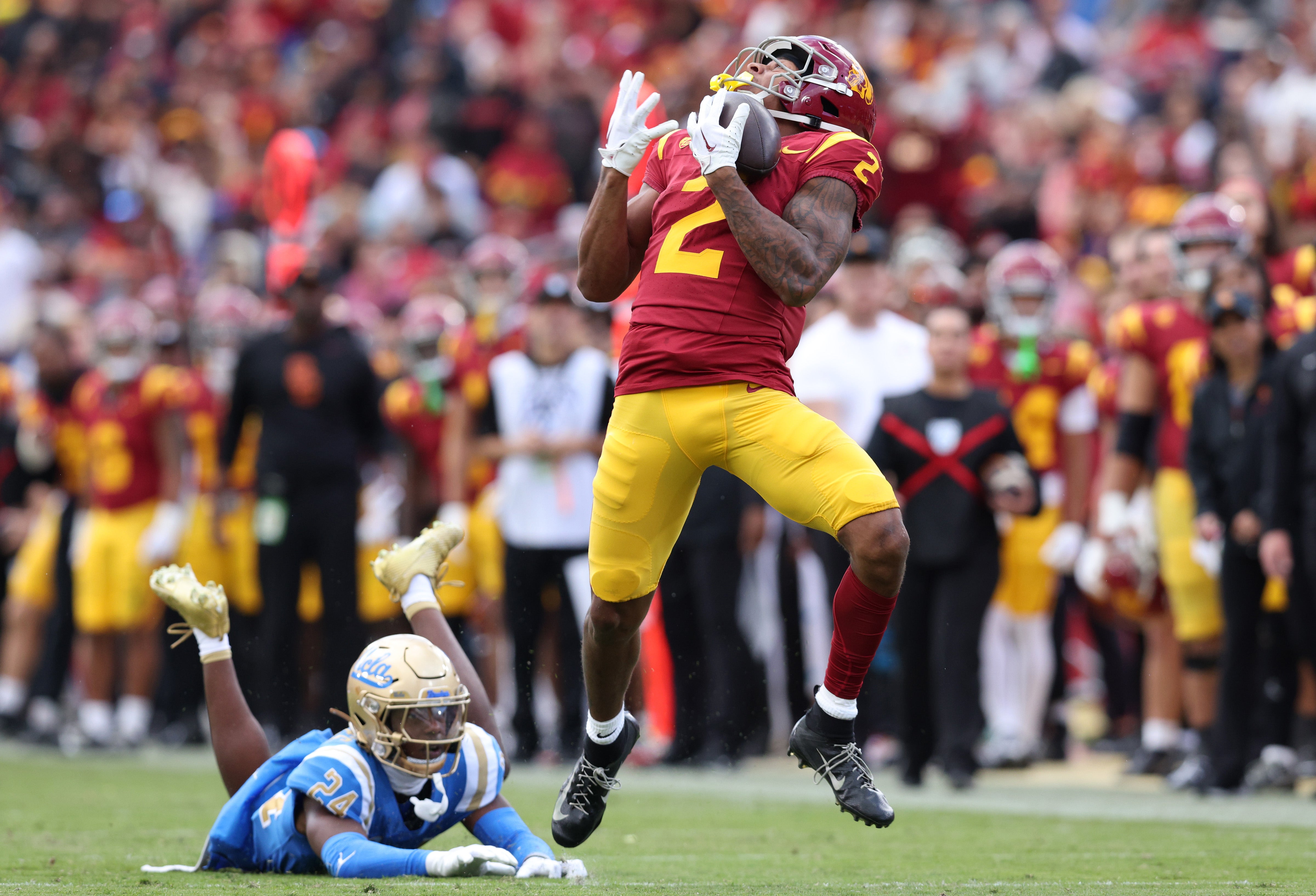 Nov 18, 2023; Los Angeles, California, USA; USC Trojans wide receiver Brenden Rice (2) catches a touchdown against UCLA Bruins defensive back Jaylin Davies (24) during the second quarter at United Airlines Field at Los Angeles Memorial Coliseum. Mandatory Credit: Jason Parkhurst-USA TODAY Sports