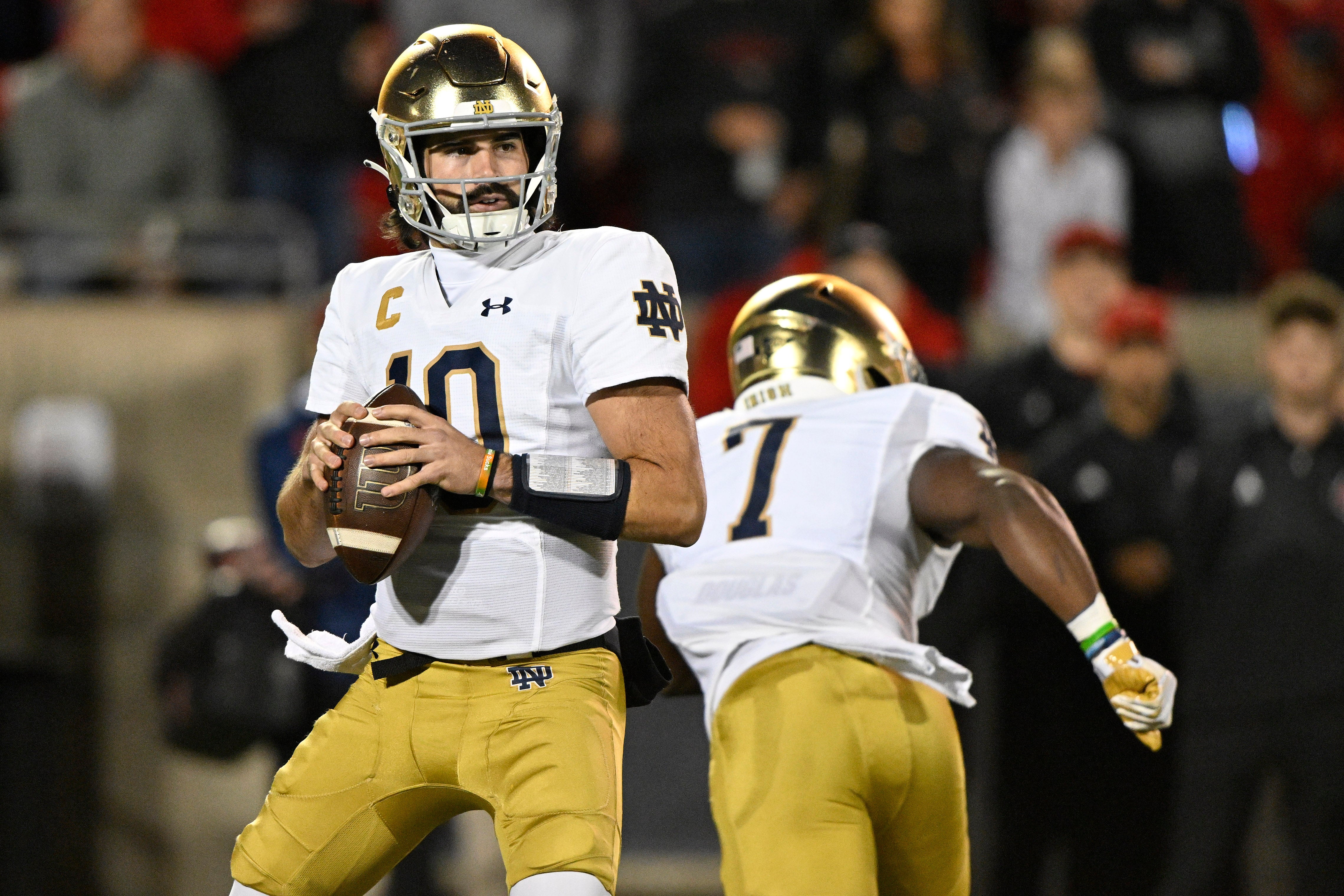 Oct 7, 2023; Louisville, Kentucky, USA; Notre Dame Fighting Irish quarterback Sam Hartman (10) looks to pass against the Louisville Cardinals during the first quarter at L&N Federal Credit Union Stadium. Mandatory Credit: Jamie Rhodes-USA TODAY Sports