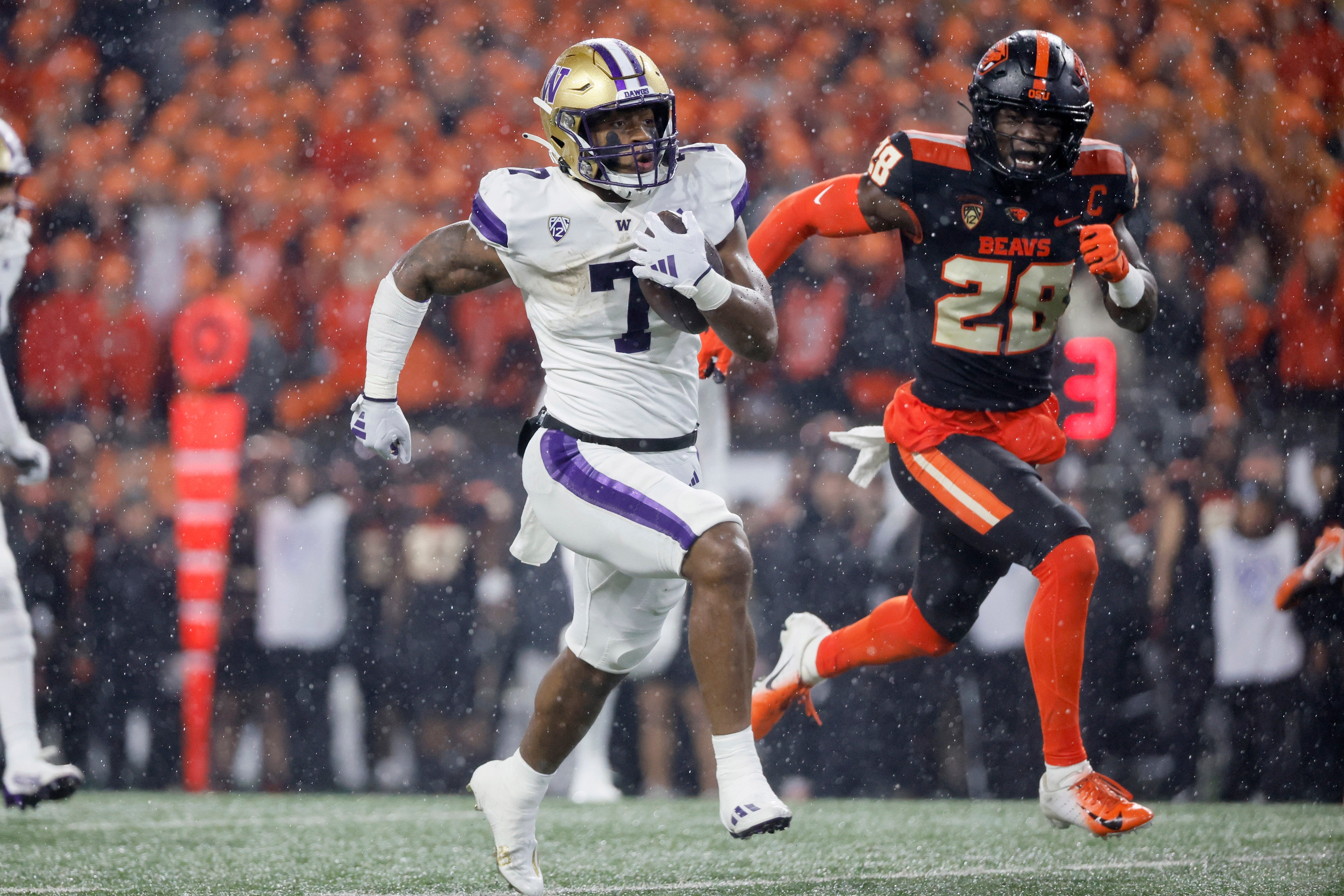 Nov 18, 2023; Corvallis, Oregon, USA; Washington Huskies running back Dillon Johnson (7) runs the ball against Oregon State Beavers defensive back Kitan Oladapo (28) during the first half at Reser Stadium. Mandatory Credit: Soobum Im-USA TODAY Sports