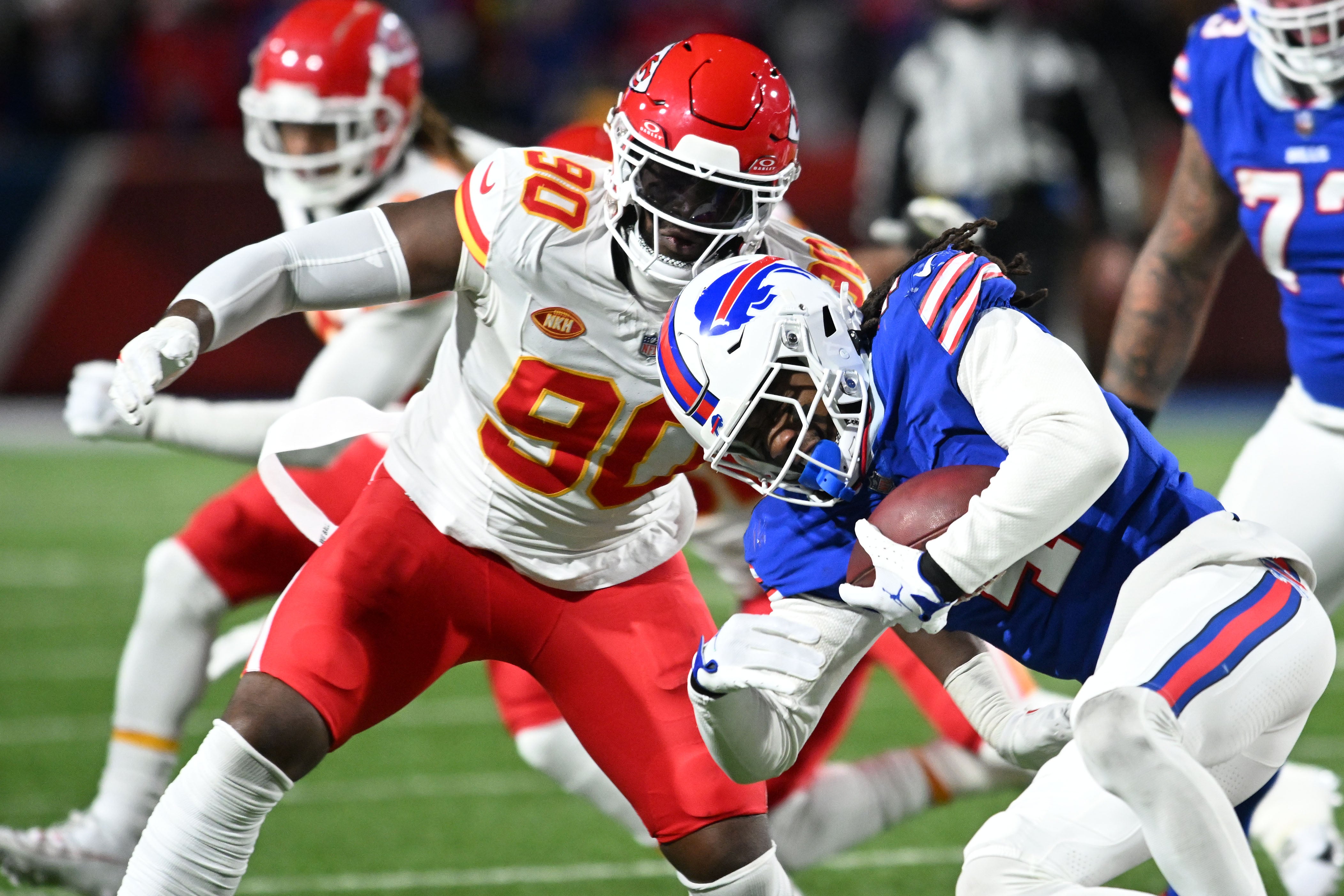 Buffalo Bills running back James Cook rushes the ball against Kansas City Chiefs defensive end Charles Omenihu in the first half of the 2024 AFC divisional round game at Highmark Stadium.