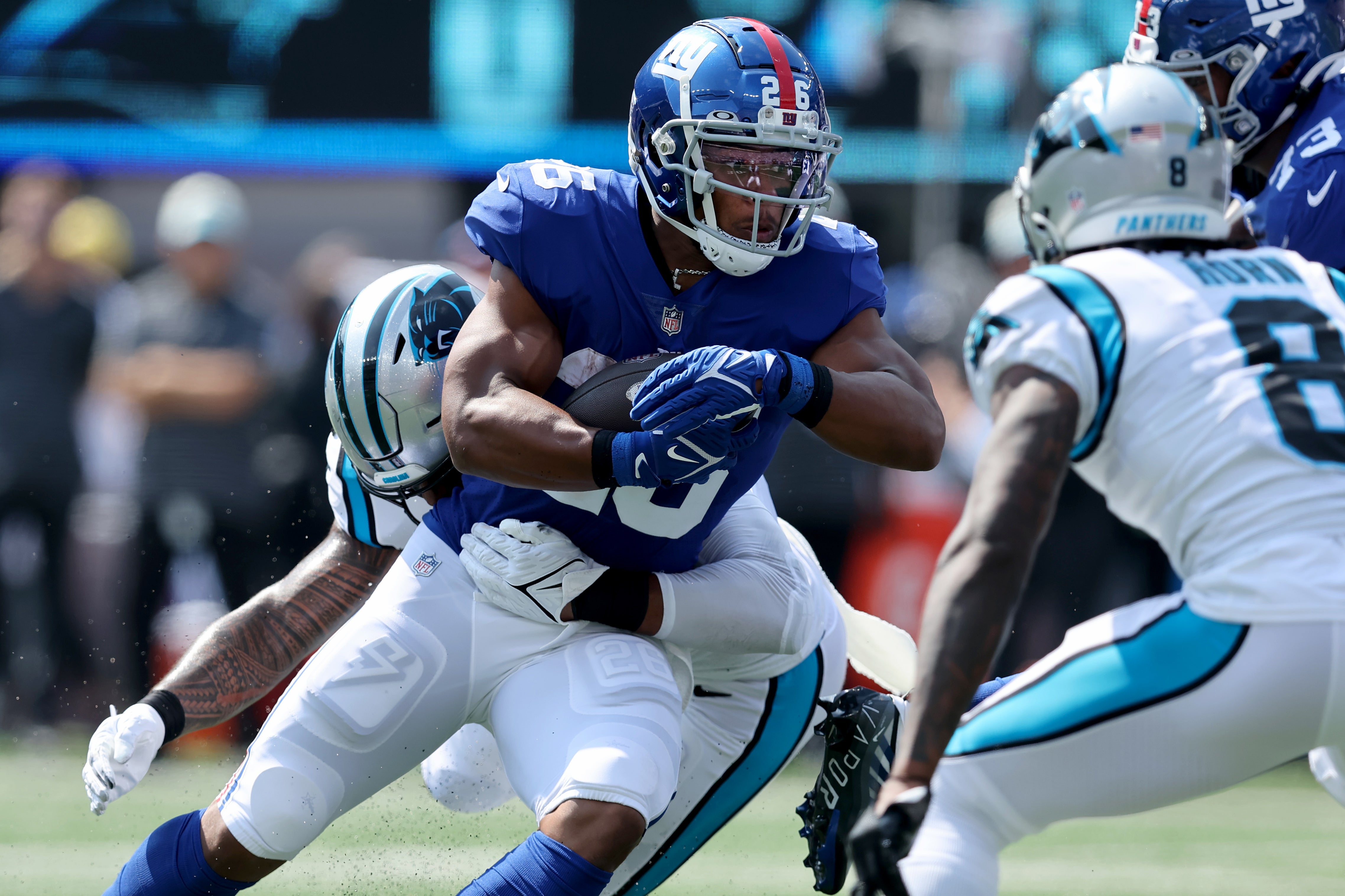 Sep 18, 2022; East Rutherford, New Jersey, USA; New York Giants running back Saquon Barkley (26) runs with the ball against Carolina Panthers linebacker Frankie Luvu (49) and cornerback Jaycee Horn (8) during the first quarter at MetLife Stadium. Mandatory Credit: Brad Penner-USA TODAY Sports