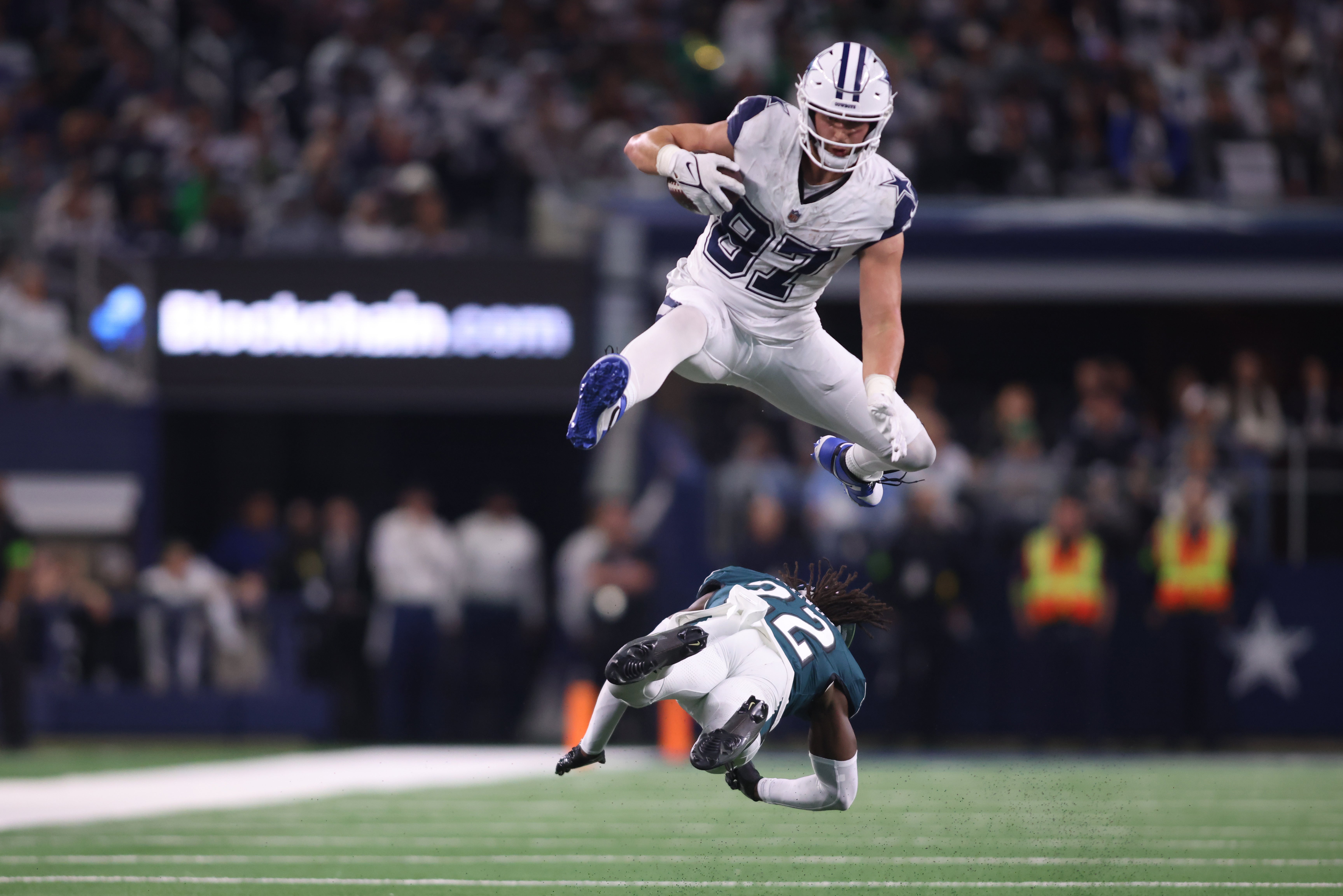 Dallas Cowboys tight end Jake Ferguson (87) jumps over Philadelphia Eagles cornerback Kelee Ringo (22) in the fourth quarter at AT&T Stadium.
