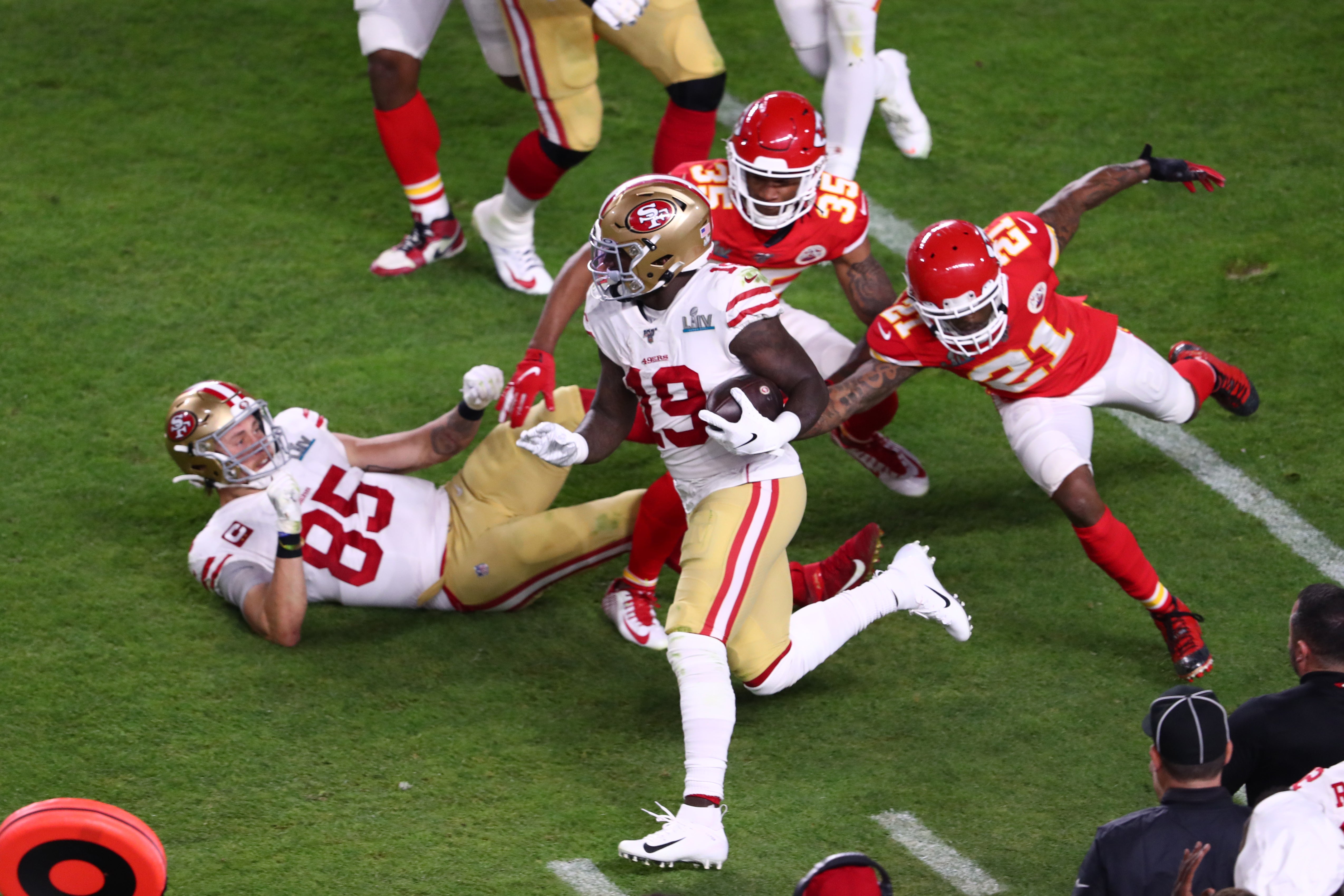 Feb 2, 2020; Miami Gardens, Florida, USA; San Francisco 49ers wide receiver Deebo Samuel (19) evades a host of Kansas City Chiefs defenders in Super Bowl LIV at Hard Rock Stadium.