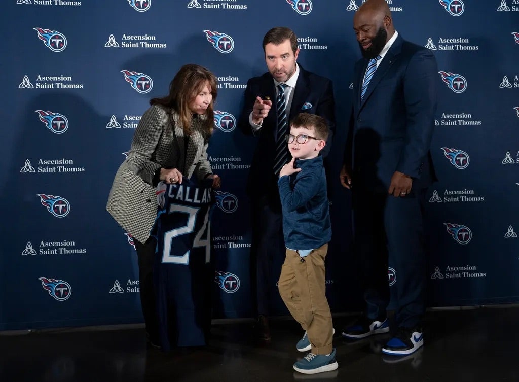 Tennessee Titans Head Coach Brian Callahan, center, asks his son, Ronan, 6, to take a seat while Titans owner Amy Adams Strunk, left, and Ran Carthon, general manager.