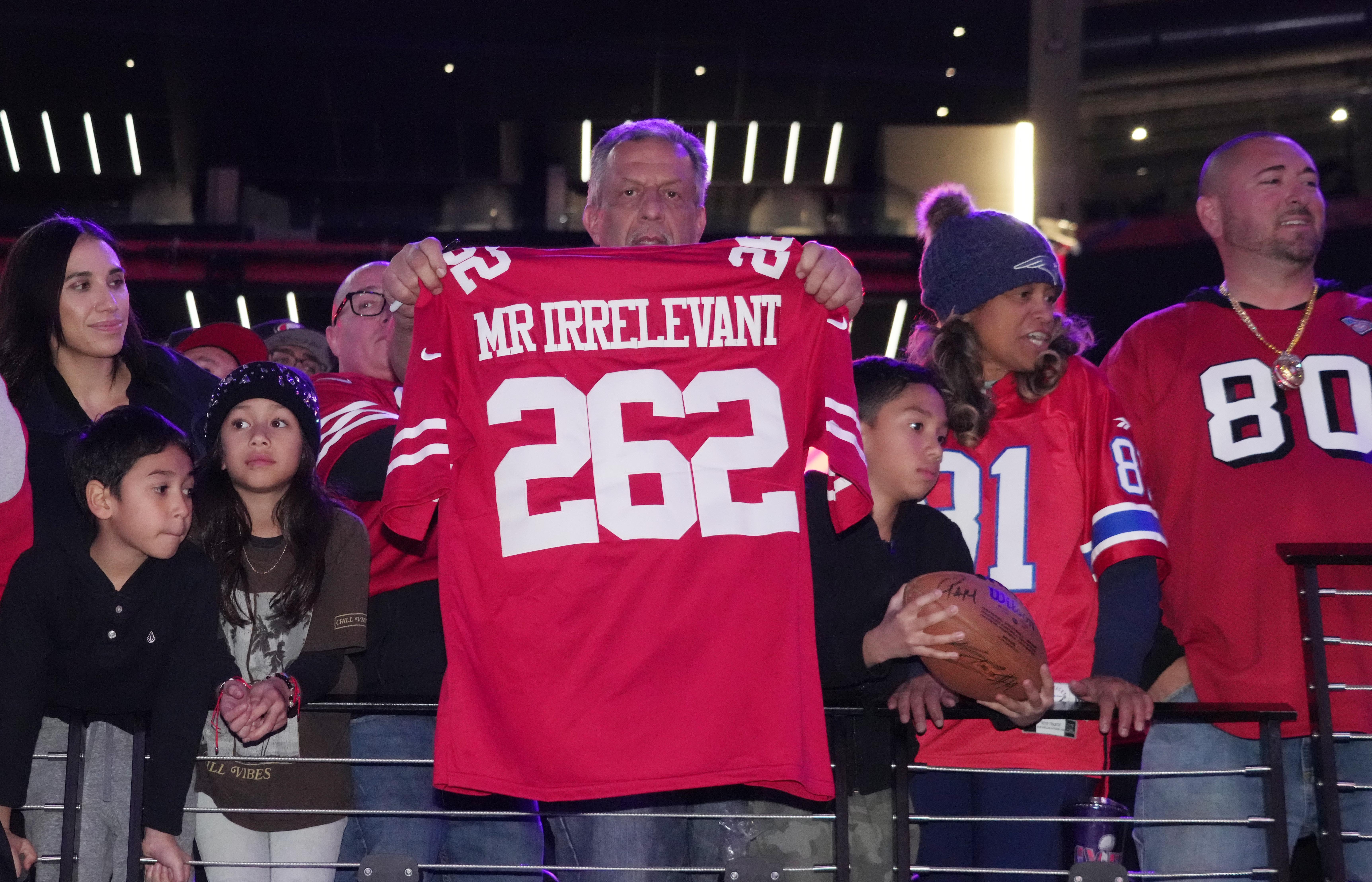 A fan of the San Francisco 49ers holds a jersey refereing quarterback Brock Purdy (not pictured) during Super Bowl LVIII Opening Night at Allegiant Stadium.