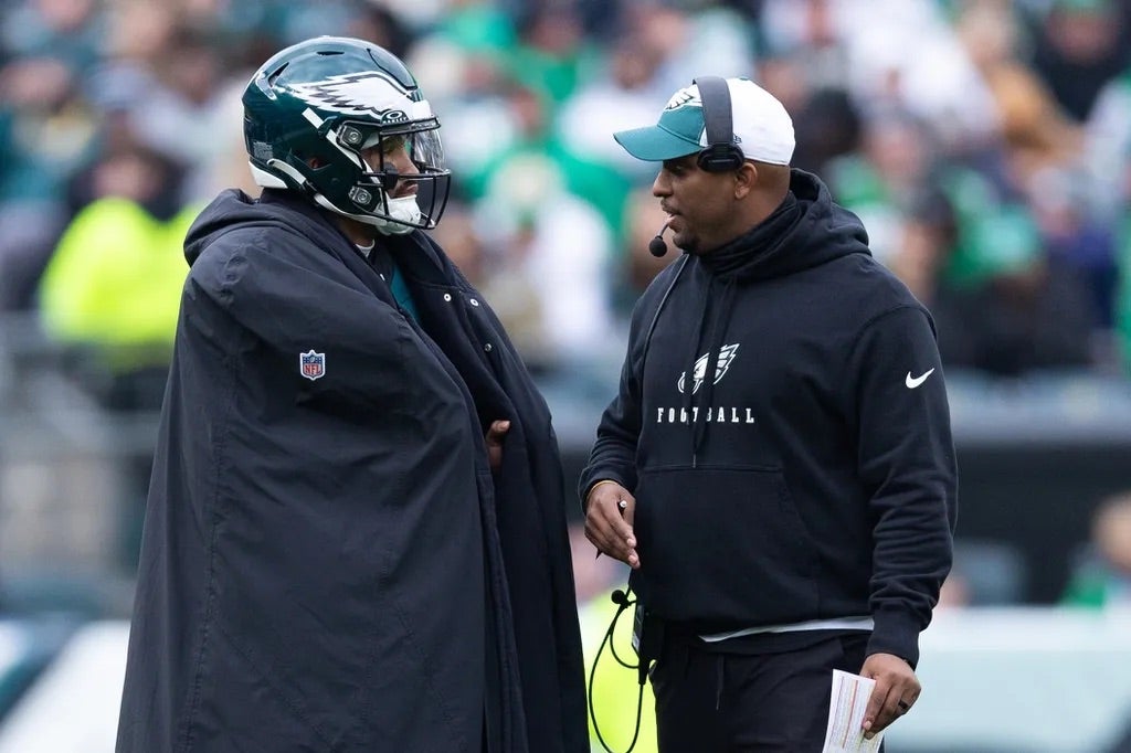 Philadelphia Eagles quarterback Jalen Hurts (L) and offensive coordinator Brian Johnson (R) talks during a timeout in the second quarter against the Arizona Cardinals at Lincoln Financial Field.