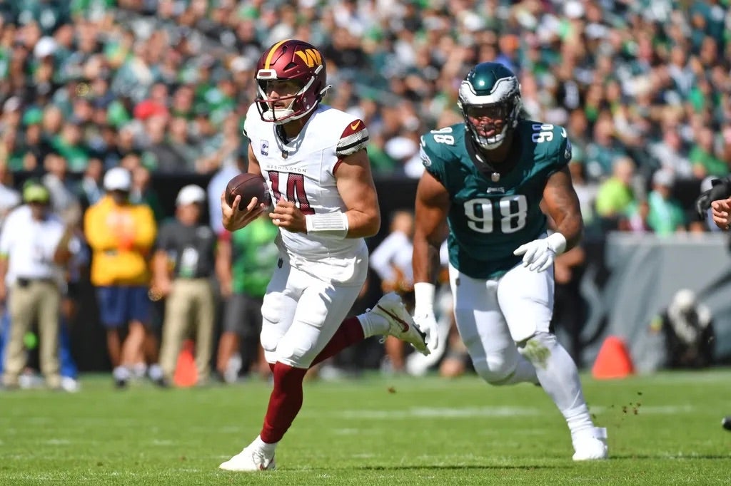 Philadelphia Eagles Washington Commanders quarterback Sam Howell (14) runs past Philadelphia Eagles defensive tackle Jalen Carter (98) during the first quarter at Lincoln Financial Field.