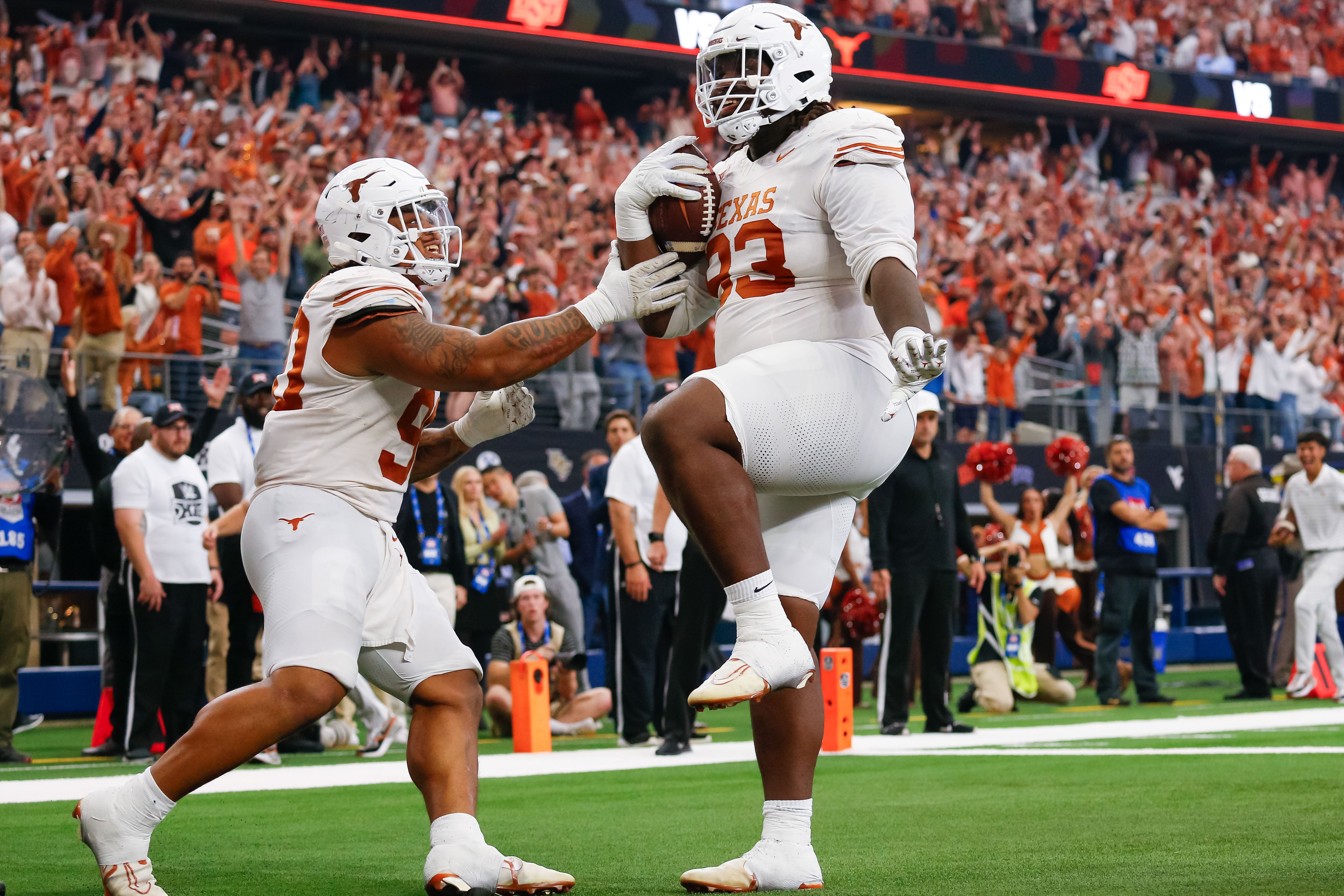Dec 2, 2023; Arlington, TX, USA; Texas Longhorns defensive lineman T'Vondre Sweat (93) celebrates his touchdown catch with teammate defensive lineman Byron Murphy II (90) during the first quarter at AT&T Stadium.