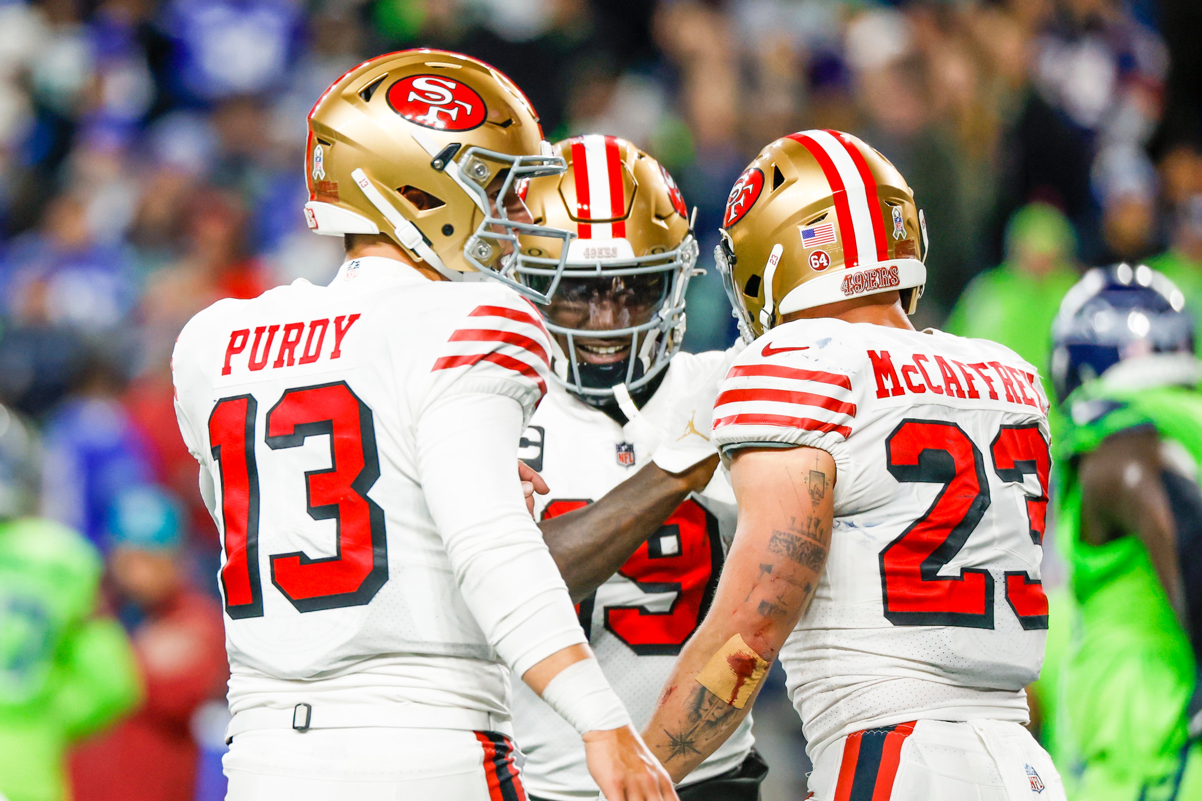 Nov 23, 2023; Seattle, Washington, USA; San Francisco 49ers running back Christian McCaffrey (23) celebrates with quarterback Brock Purdy (13) and wide receiver Deebo Samuel (19) after catching a touchdown pass from Purdy against the Seattle Seahawks during the second quarter at Lumen Field.