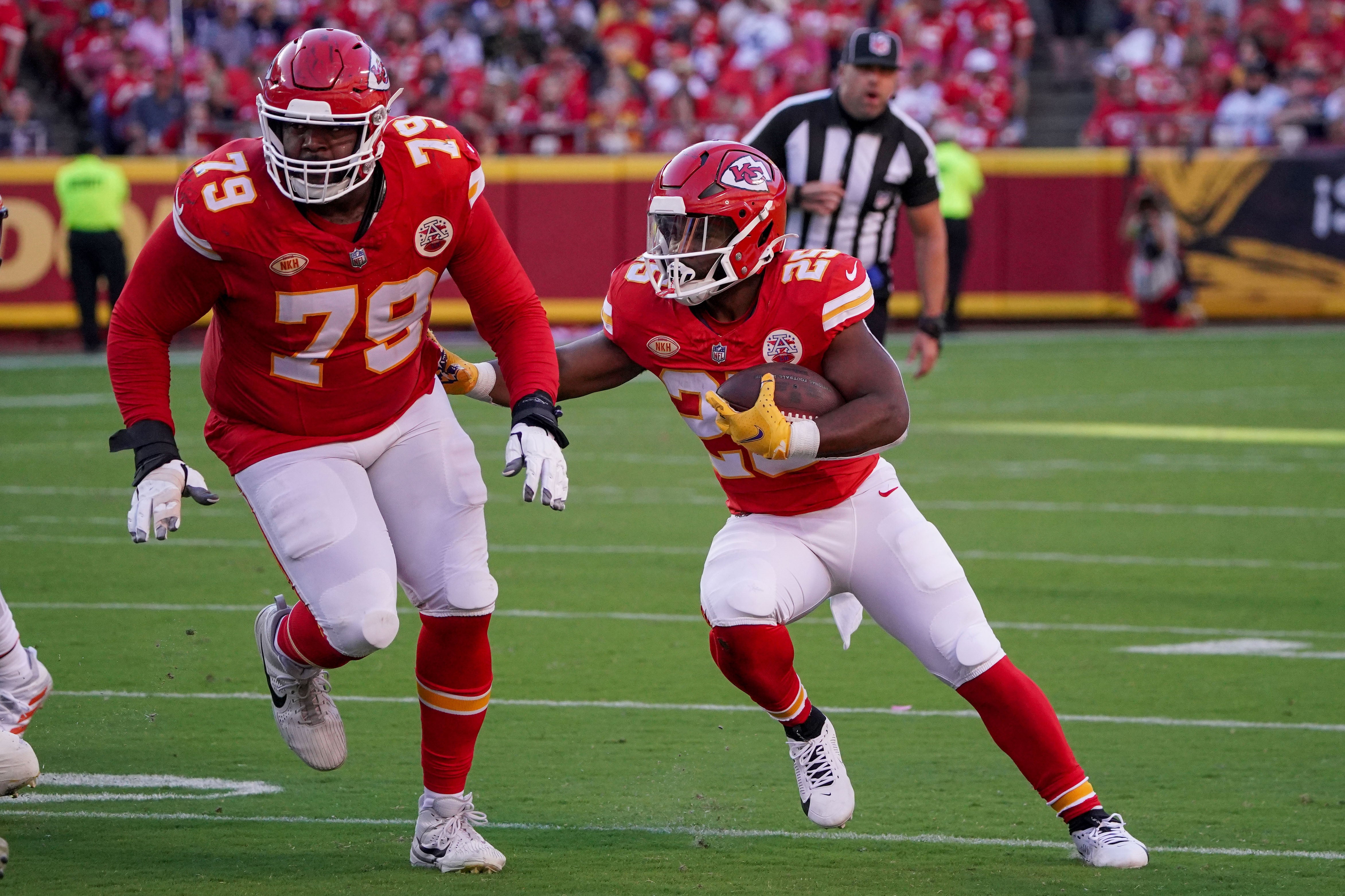 Sep 24, 2023; Kansas City, Missouri, USA; Kansas City Chiefs running back Clyde Edwards-Helaire (25) runs the ball as offensive tackle Donovan Smith (79) blocks against the Chicago Bears during the game at GEHA Field at Arrowhead Stadium. Mandatory Credit: Denny Medley-USA TODAY Sports