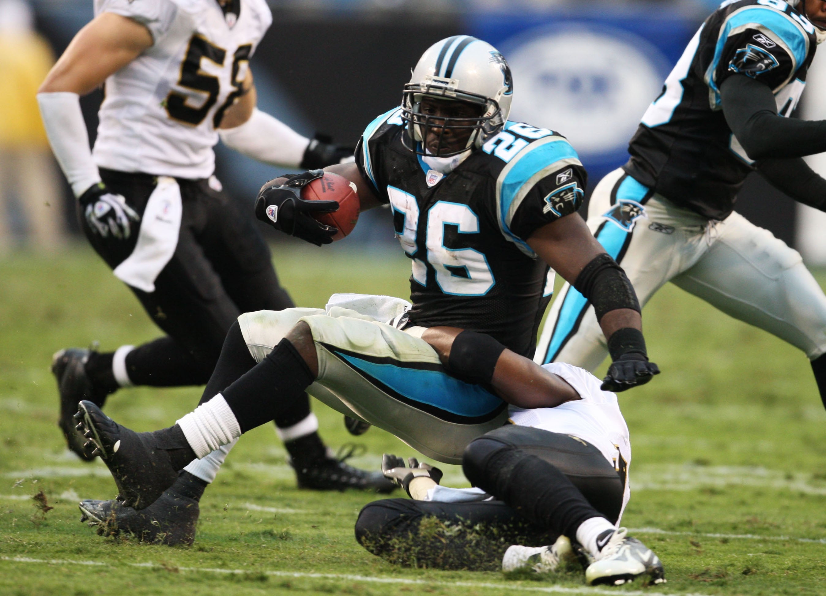 Nov 25, 2007, Charlotte, NC, USA; Carolina Panthers running back DeShaun Foster (26) fumbles as he is tackled by New Orleans Saints safety Roman Harper (41) in the Saints 31-6 victory against the Panthers at Bank of America Stadium. Mandatory Credit: Bob Donnan-USA TODAY Sports