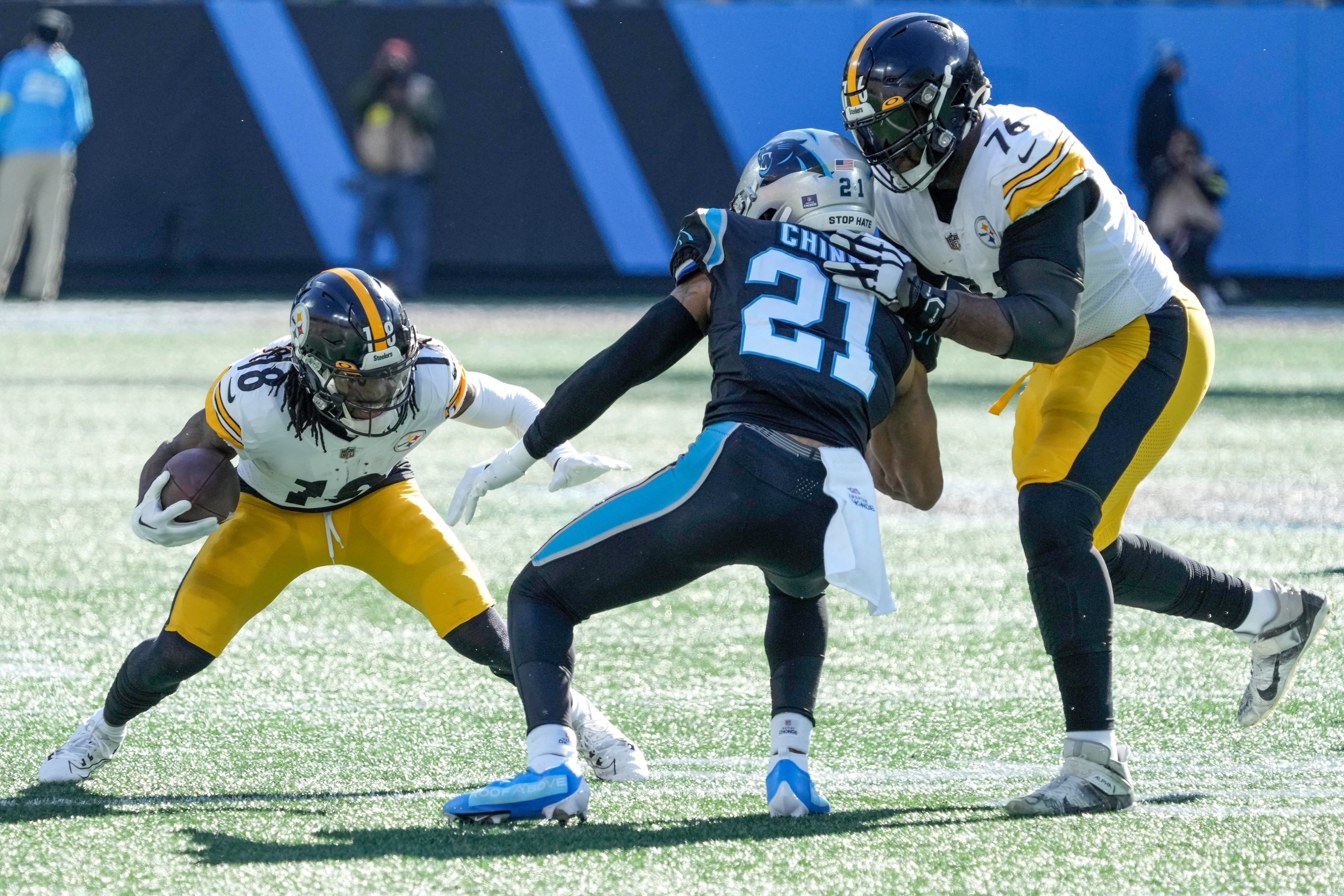 fDec 18, 2022; Charlotte, North Carolina, USA; Pittsburgh Steelers wide receiver Diontae Johnson (18) tries to elude Carolina Panthers safety Jeremy Chinn (21) with the help of offensive tackle Chukwuma Okorafor (76) during the first quarter at Bank of America Stadium. Mandatory Credit: Jim Dedmon-USA TODAY Sports