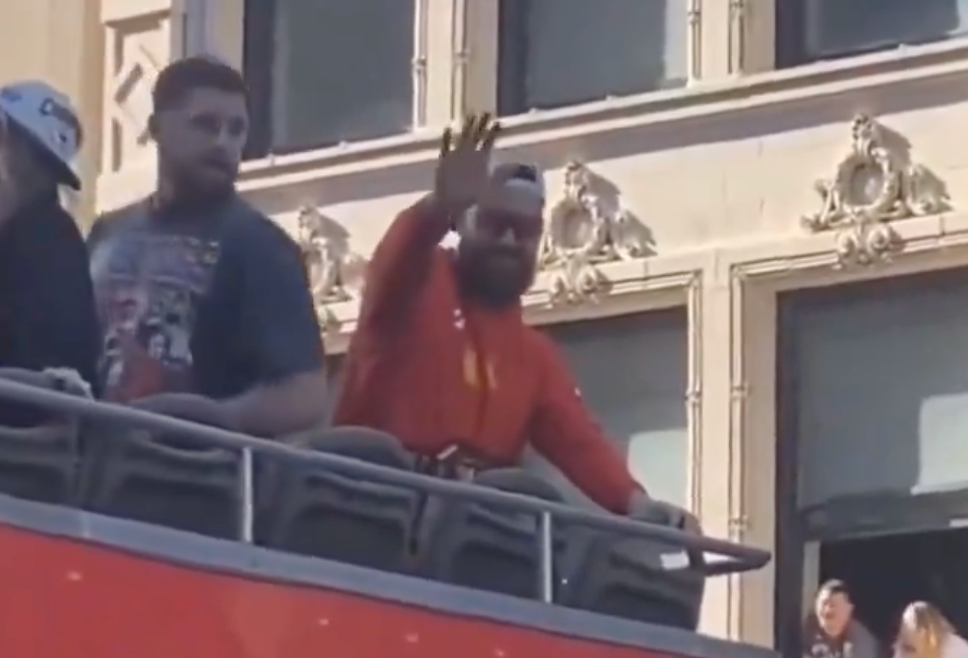 Travis Kelce waives at a young fan with a funny Taylor Swift inspired sign.