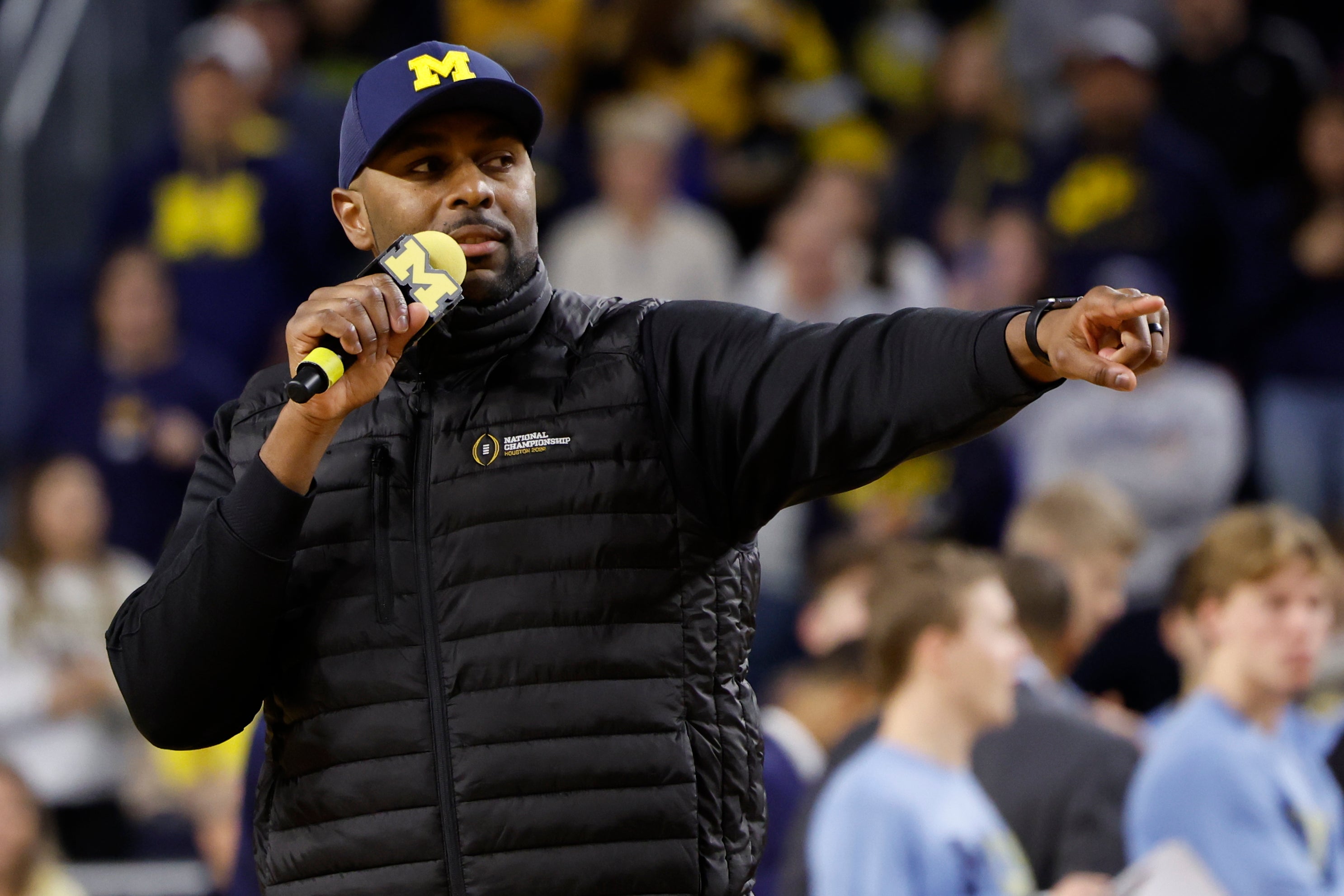 Jan 27, 2024; Ann Arbor, Michigan, USA; Michigan Wolverines head football coach Sherrone Moore addresses the basketball crowd during a time out against the Iowa Hawkeyes at Crisler Center.