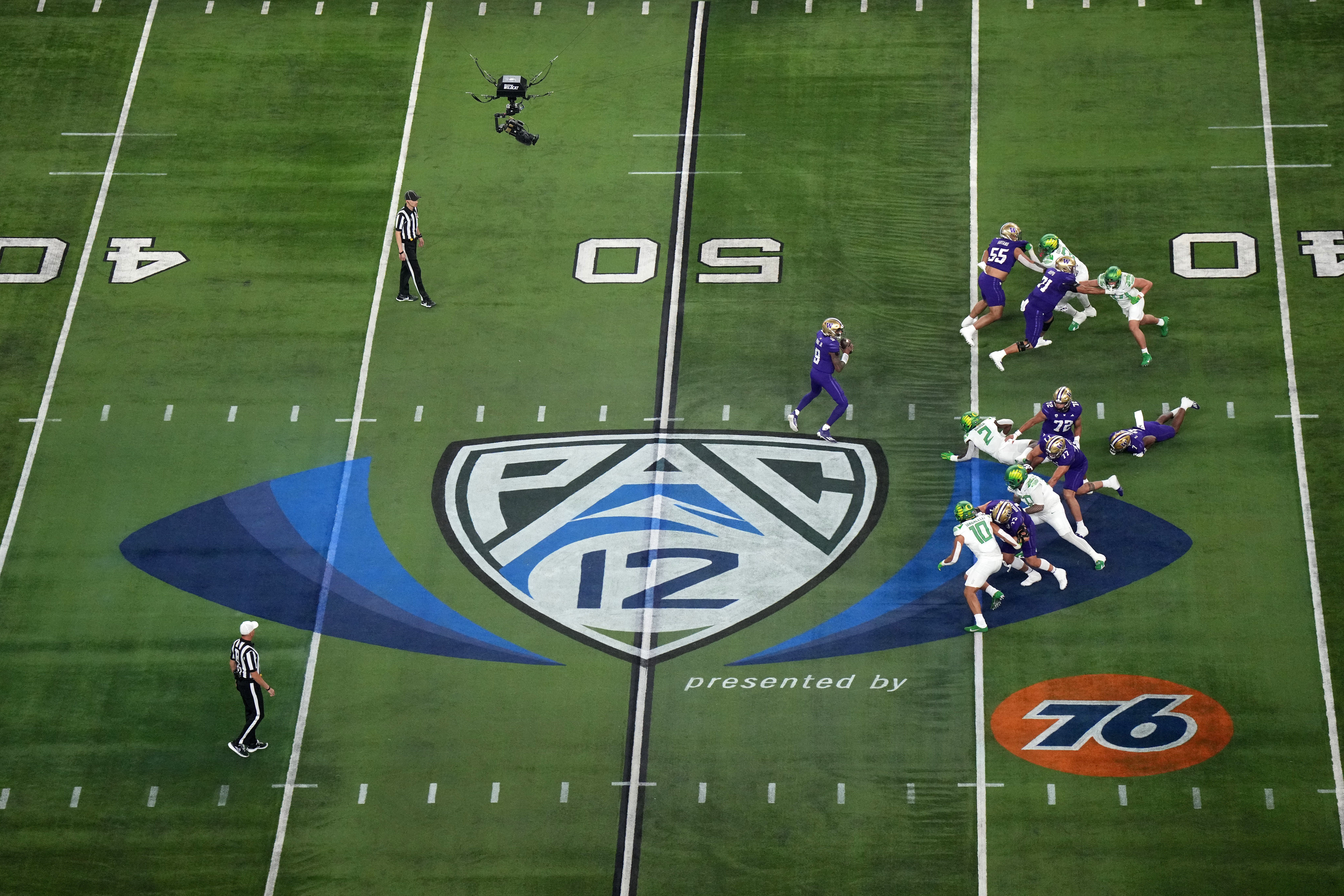 Dec 1, 2023; Las Vegas, NV, USA; A general overall view as Washington Huskies quarterback Michael Penix Jr. (9)] throws the ball at midfield on the Pac-12 Conference logo against the Oregon Ducks in the first half at Allegiant Stadium.
