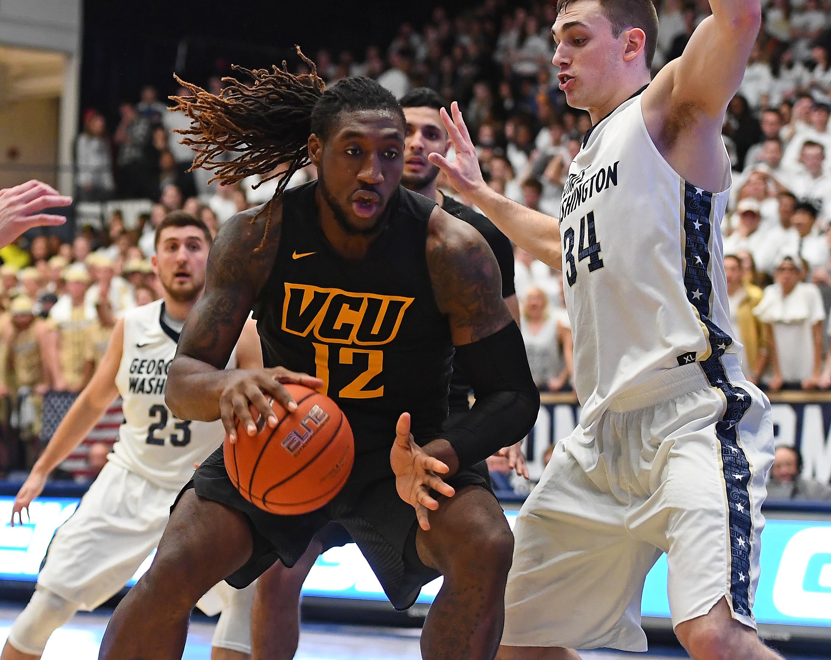 Feb 8, 2017; Washington, DC, USA; Virginia Commonwealth Rams forward Mo Alie-Cox (12) dribbles as George Washington Colonials forward Tyler Cavanaugh (34) defends during the first half at Charles E. Smith Center.