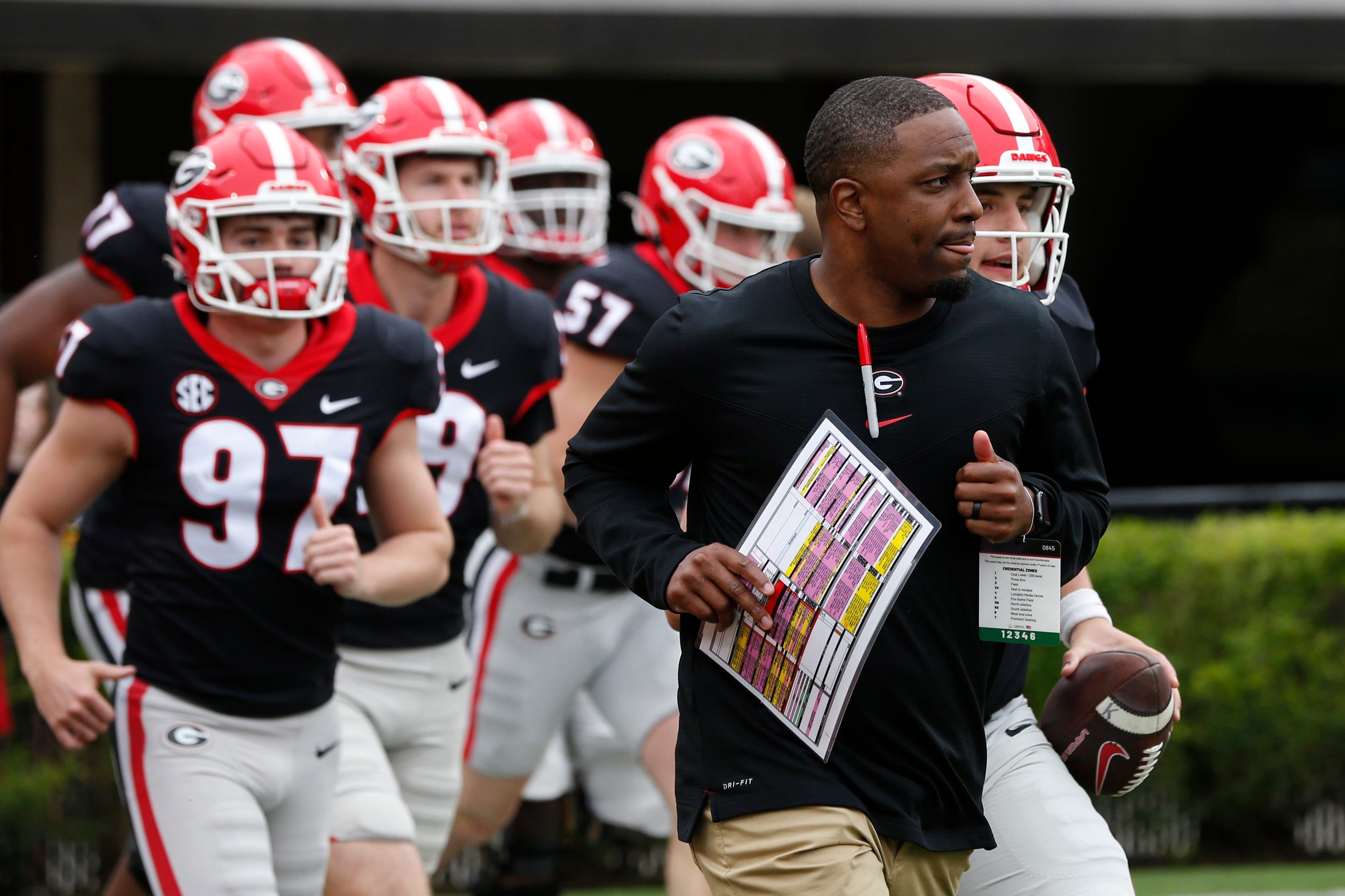 Georgia receivers coach and pass game coordinator Bryan McClendon leads the black team onto the field before the start of the G-Day spring football game in Athens, Ga., on Saturday, April 16, 2022.
