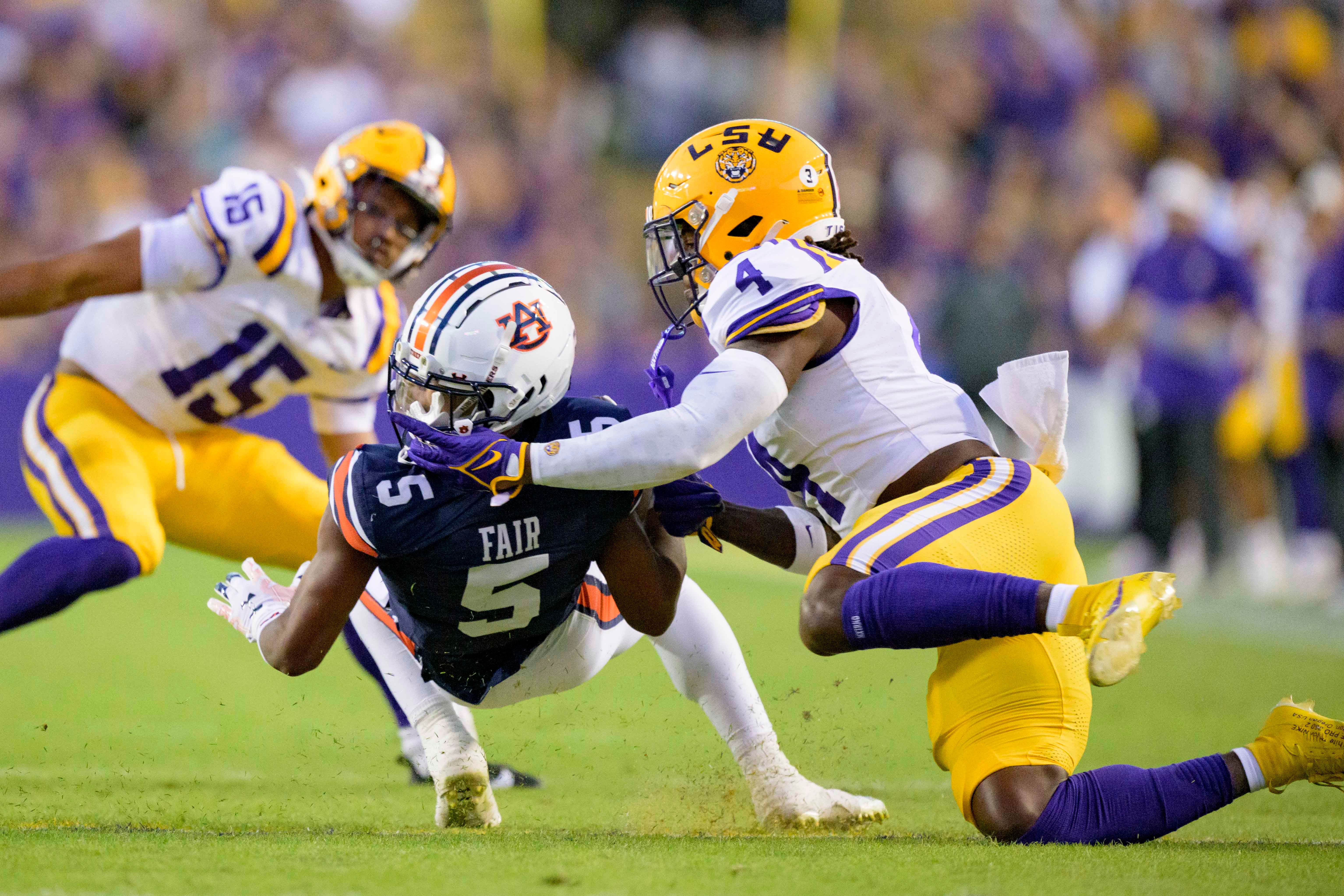 Oct 14, 2023; Baton Rouge, Louisiana, USA; LSU Tigers linebacker Harold Perkins Jr. (4) gets his fingers caught in the helmet of Auburn Tigers wide receiver Jay Fair (5) but there was no flag during the first quarter at Tiger Stadium. Mandatory Credit: Matthew Hinton-USA TODAY Sports