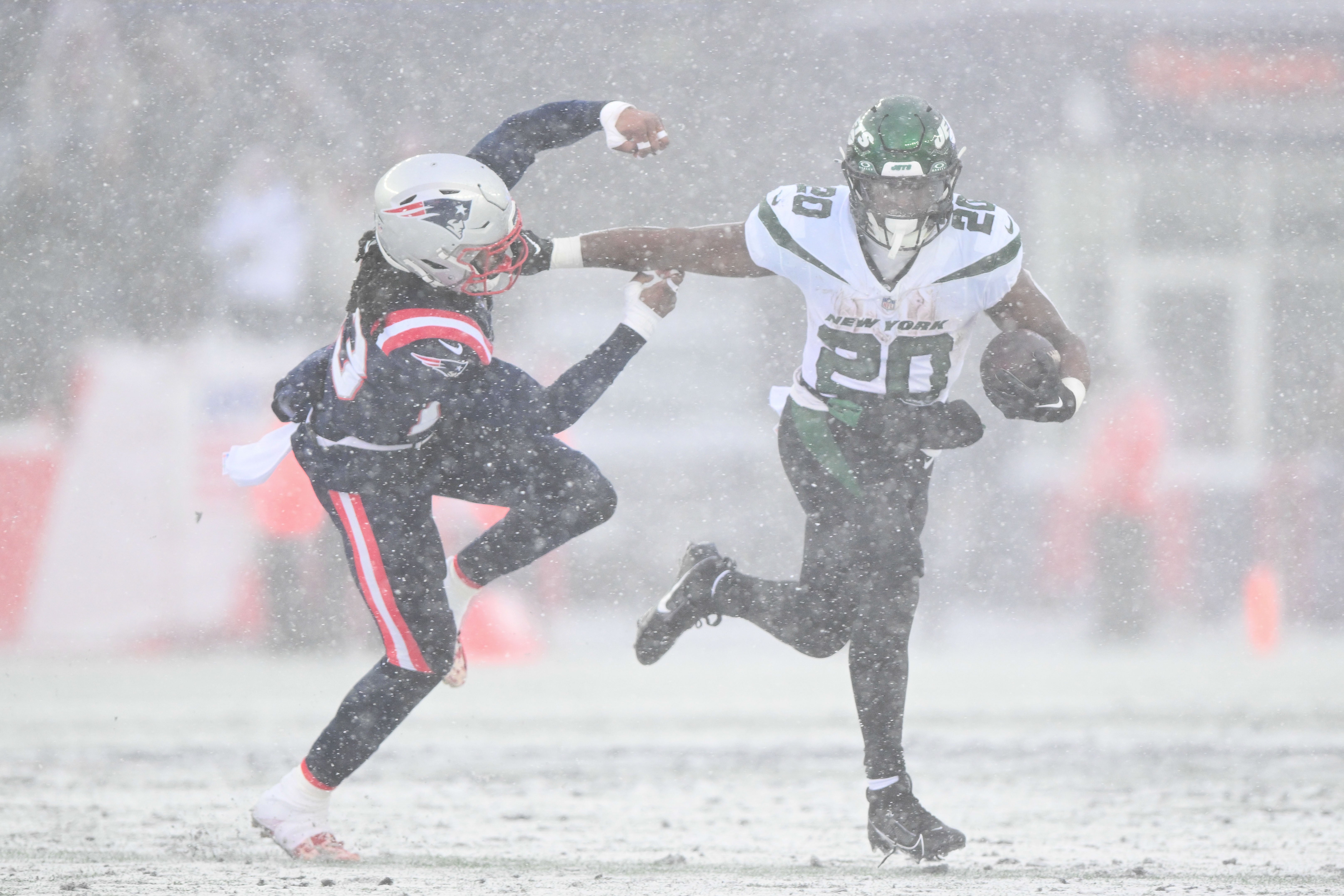 New York Jets running back Breece Hall (20) breaks a tackle from New England Patriots safety Kyle Dugger (23) during the first half at Gillette Stadium.