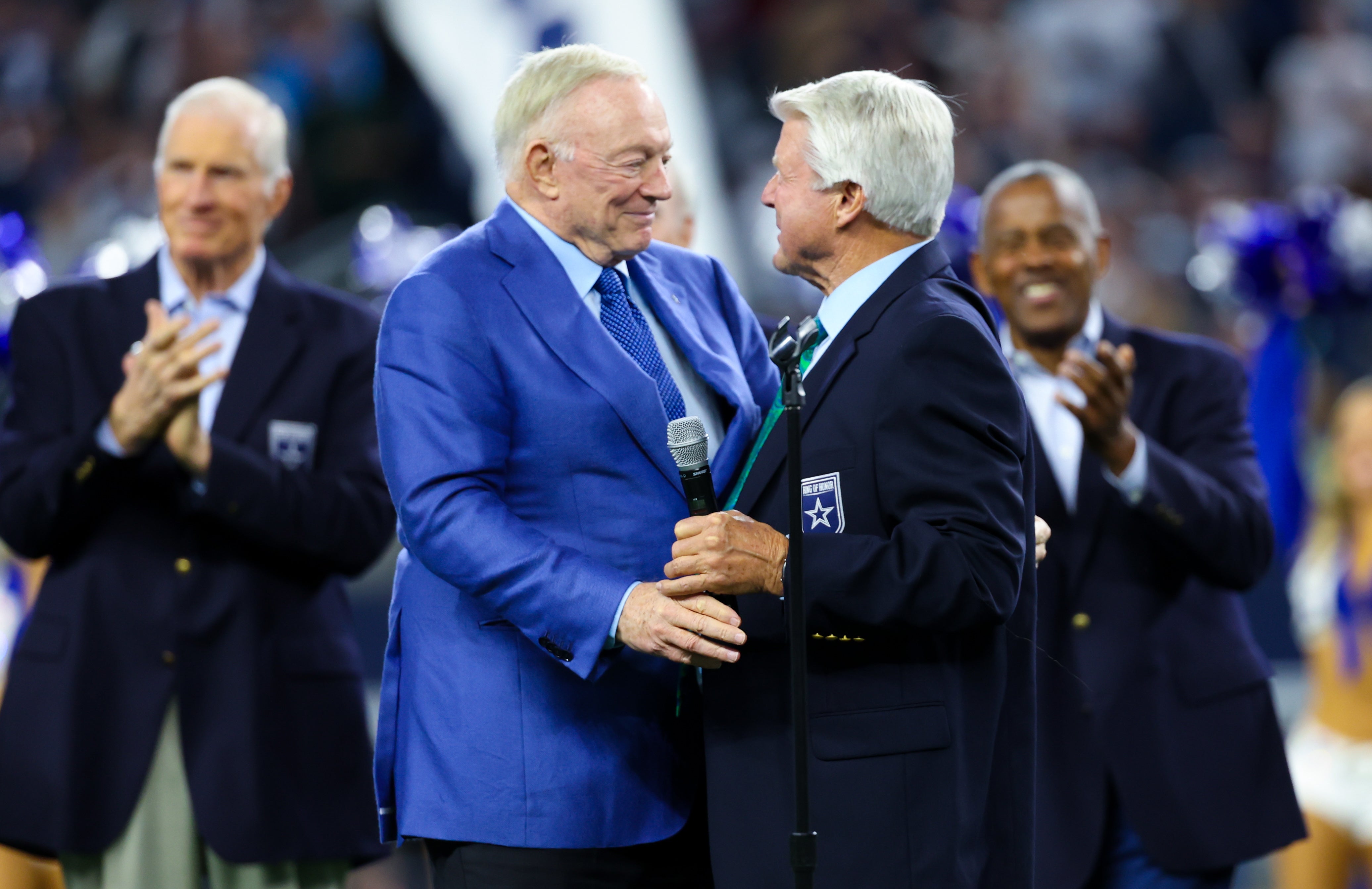 Dallas Cowboys former head coach Jimmy Johnson hugs owner Jerry Jones after being inducted into the ring of honor at halftime of the game against the Detroit Lions at AT&T Stadium.