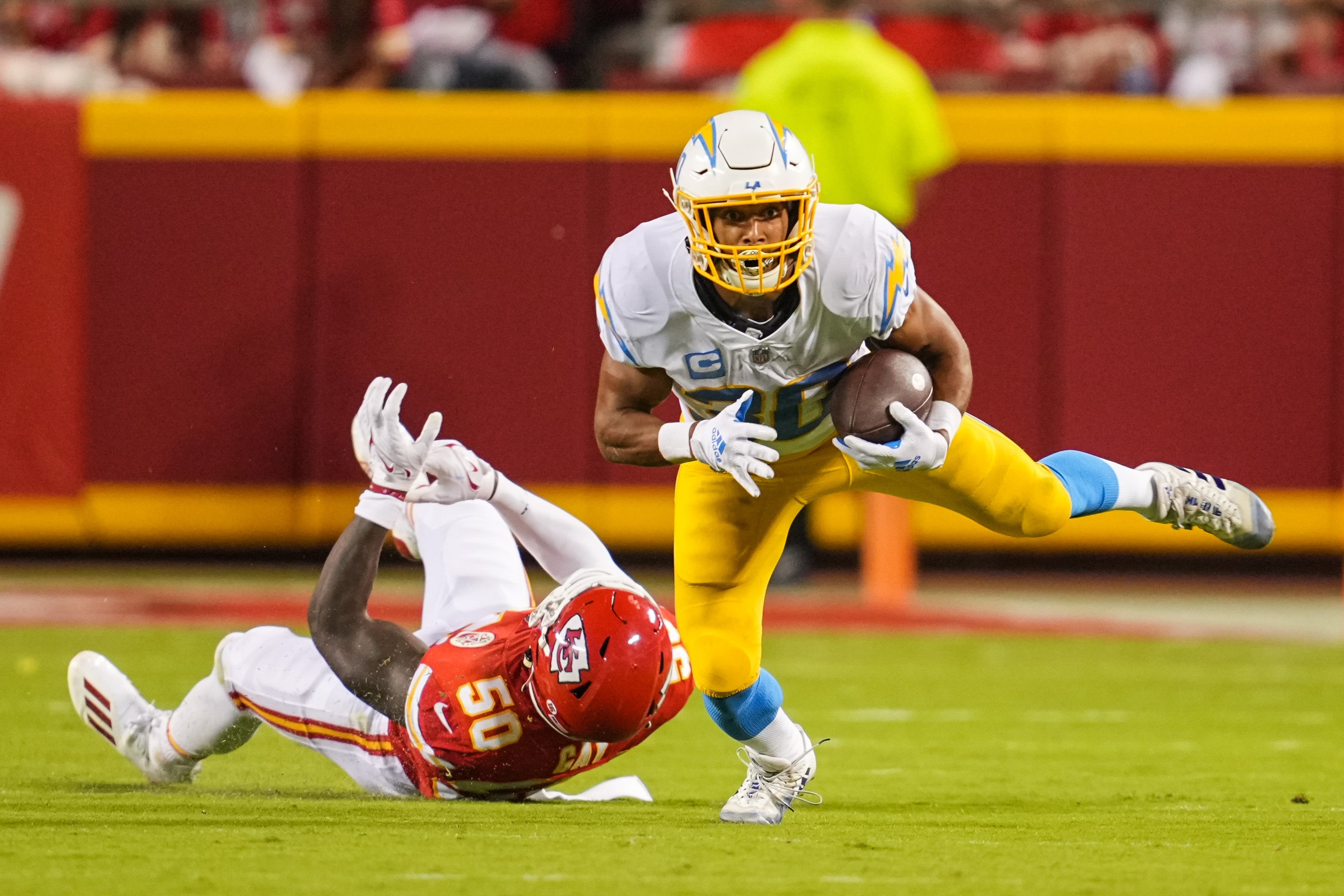 Sep 15, 2022; Kansas City, Missouri, USA; Los Angeles Chargers running back Austin Ekeler (30) runs with the ball past Kansas City Chiefs linebacker Willie Gay (50) during the second half at GEHA Field at Arrowhead Stadium.