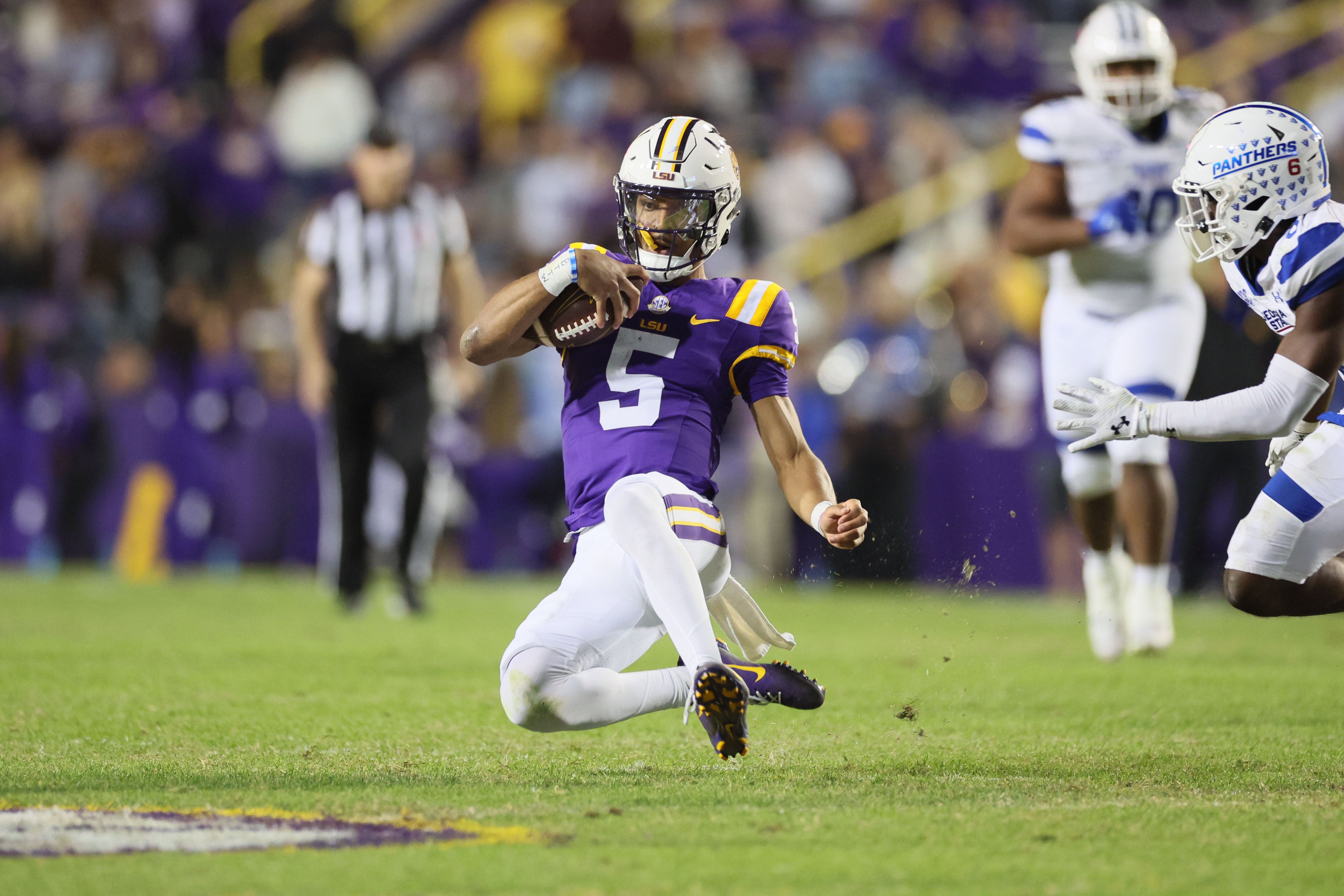 Nov 18, 2023; Baton Rouge, Louisiana, USA; LSU Tigers quarterback Jayden Daniels (5) slides after a run as Georgia State Panthers safety Jeremiah Johnson (6) looks on in the third quarter at Tiger Stadium.