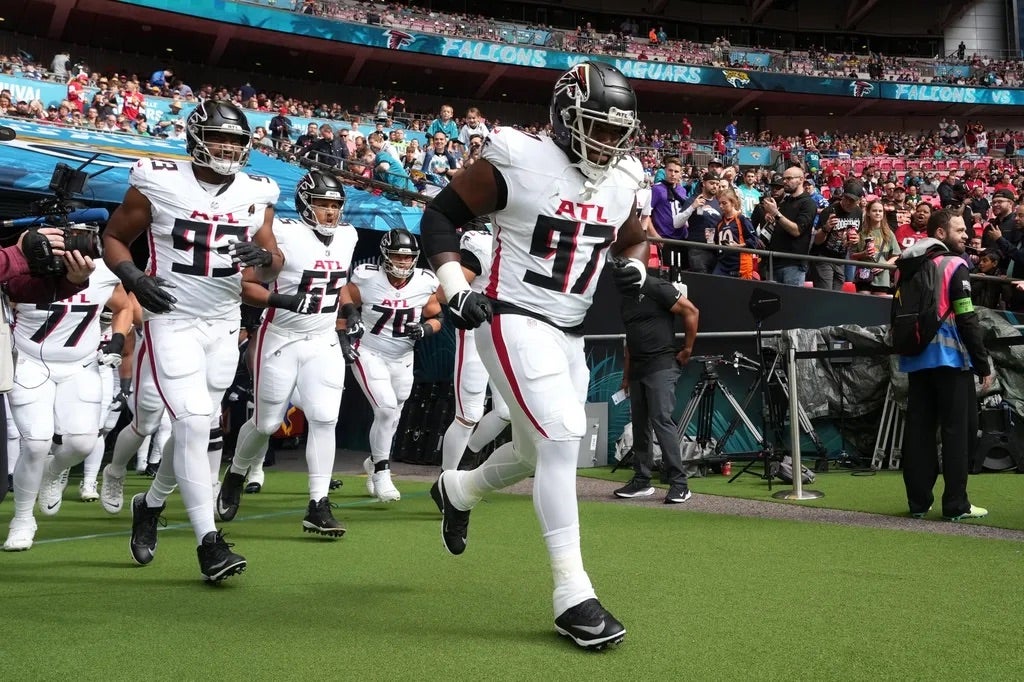 Atlanta Falcons defensive end Grady Jarrett (97), defensive tackle Calais Campbell (93) and guard Matthew Bergeron (65) enter the field during an NFL International Series game against the Jacksonville.