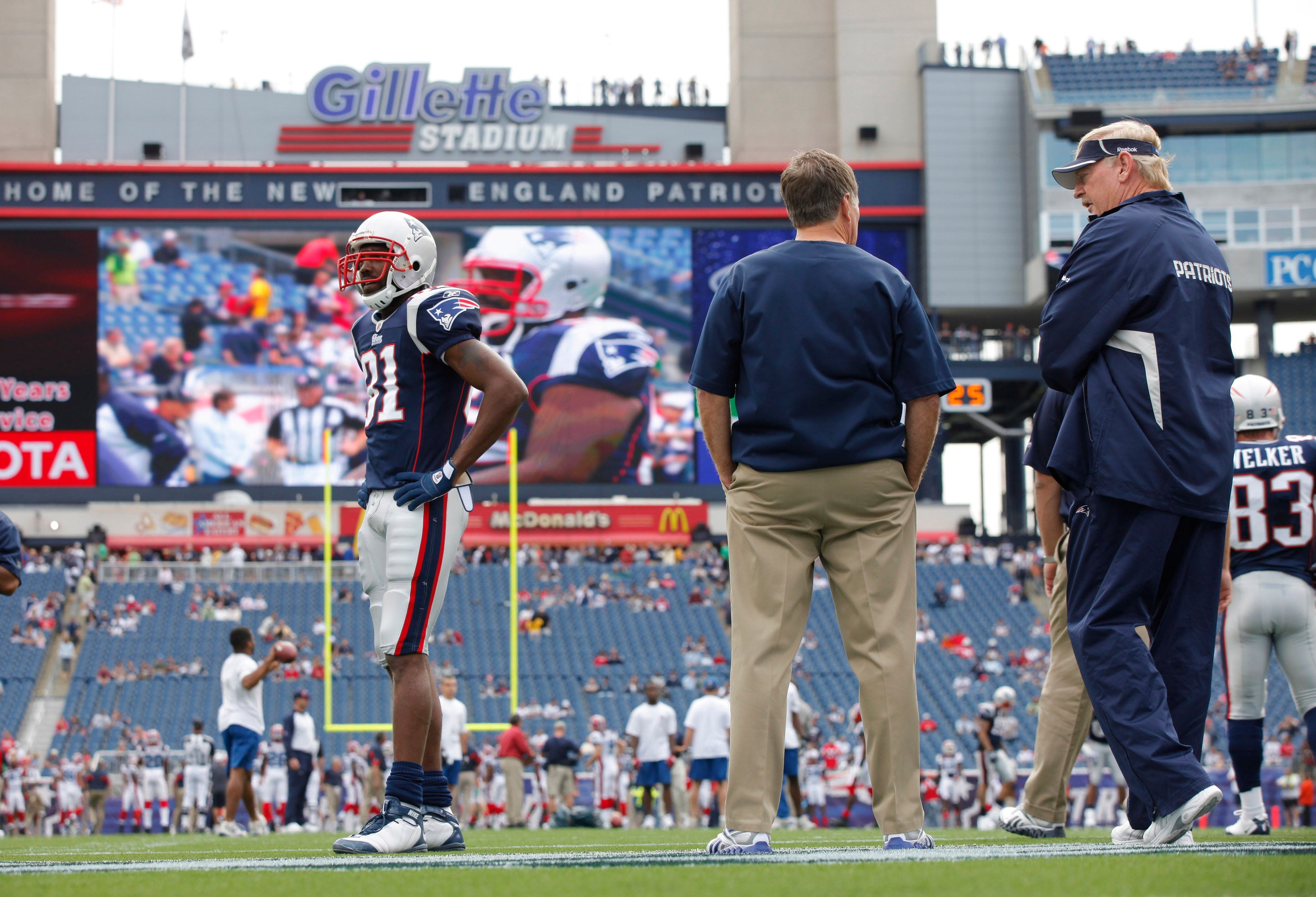 Sep 26, 2010; Foxboro, MA, USA; New England Patriots wide receiver Randy Moss (81) warms up before the start of the game as head coach Bill Belichick looks on against the Buffalo Bills at Gillette Stadium.