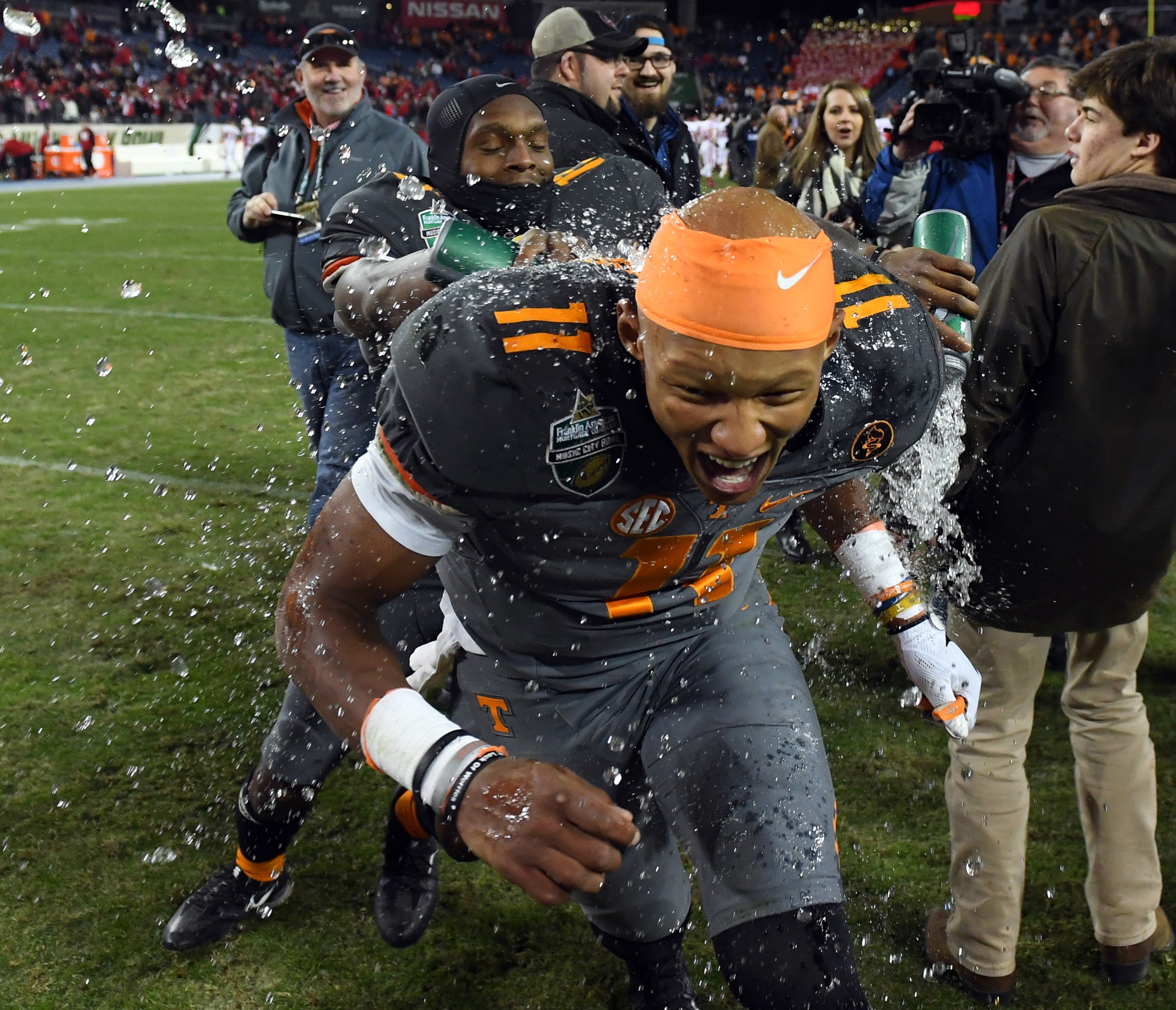 Dec 30, 2016; Nashville , TN, USA; Tennessee Volunteers quarterback Joshua Dobbs (11) is dumped with water by teammate quarterback Sheriron Jones (13) after a win over the Nebraska Cornhuskers at Nissan Stadium. Tennessee won 38-24.