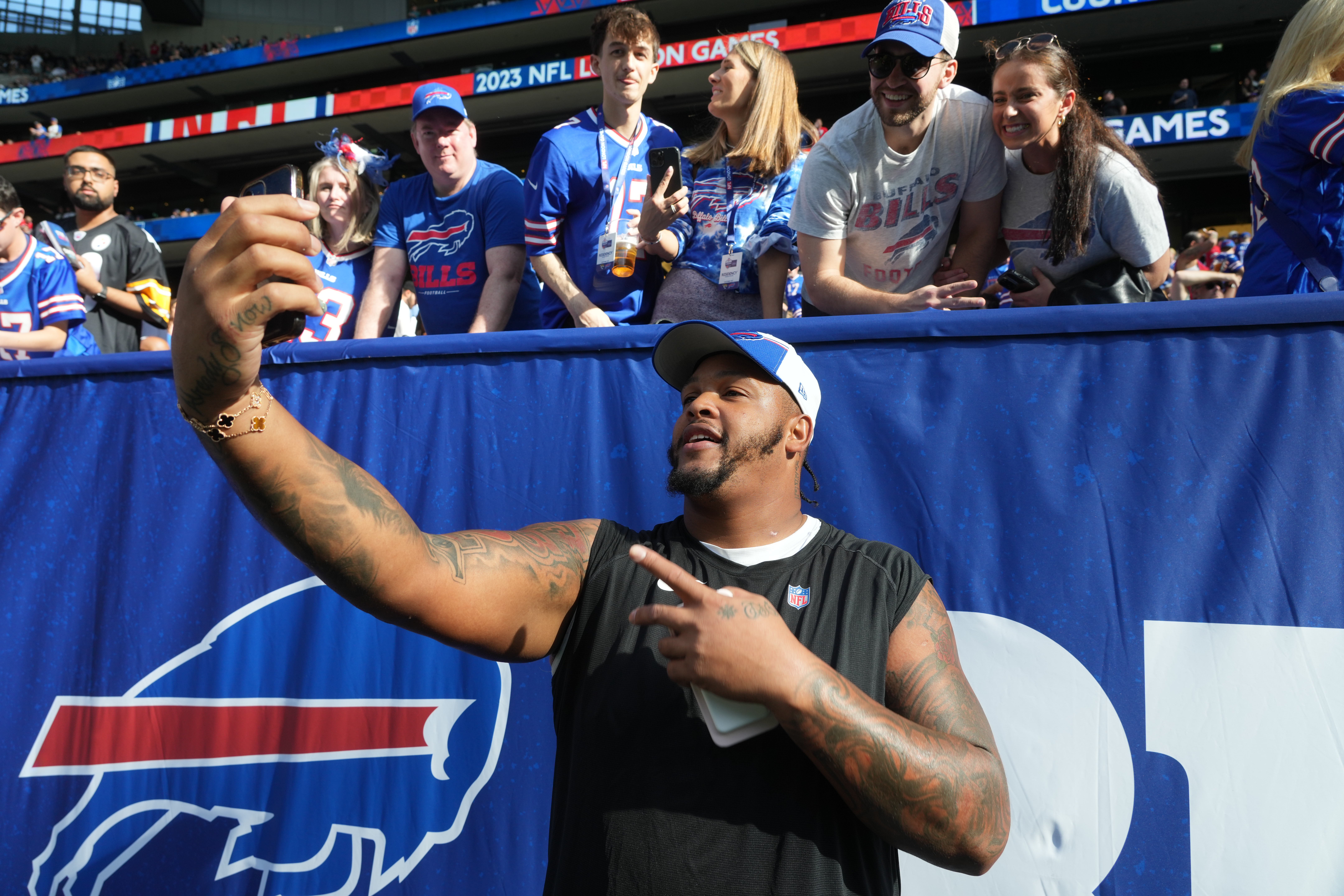 Buffalo Bills offensive tackle Dion Dawkins (73) poses with fans during an NFL International Series game against the Jacksonville Jaguars at Tottenham Hotspur Stadium.
