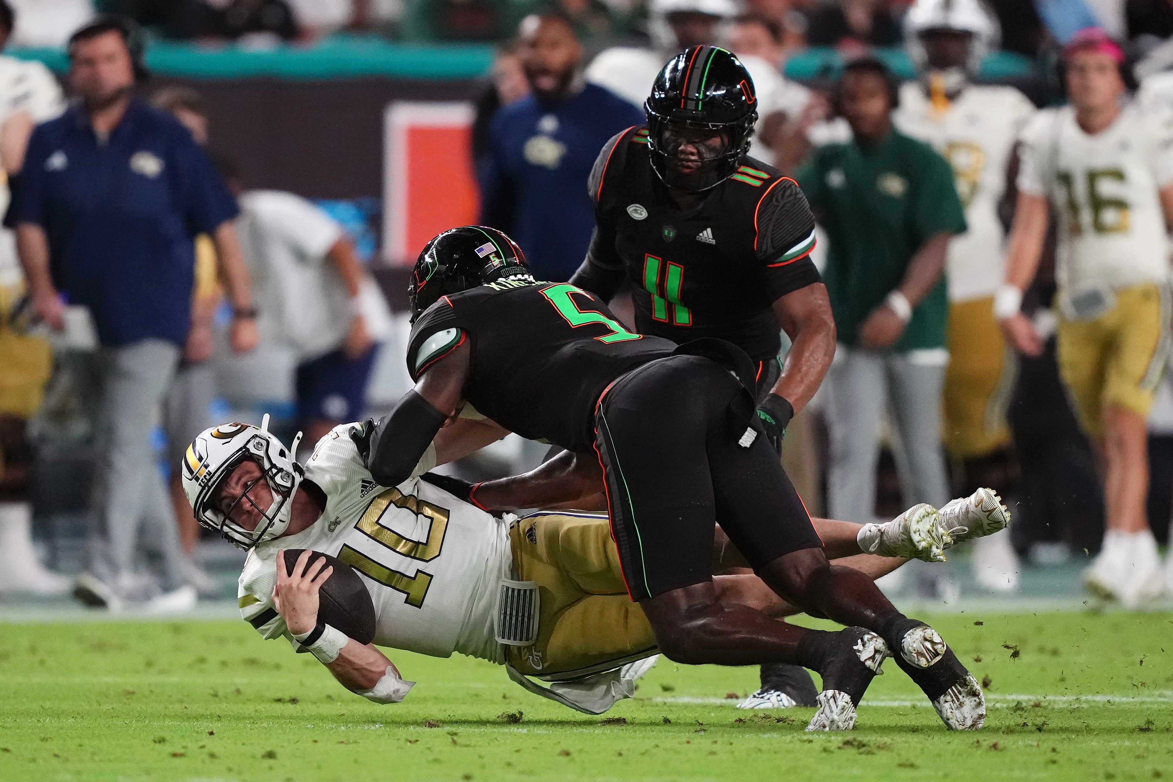 Oct 7, 2023; Miami Gardens, Florida, USA; Miami Hurricanes safety Kamren Kinchens (5) tackles Georgia Tech Yellow Jackets quarterback Haynes King (10) in the first half at Hard Rock Stadium.