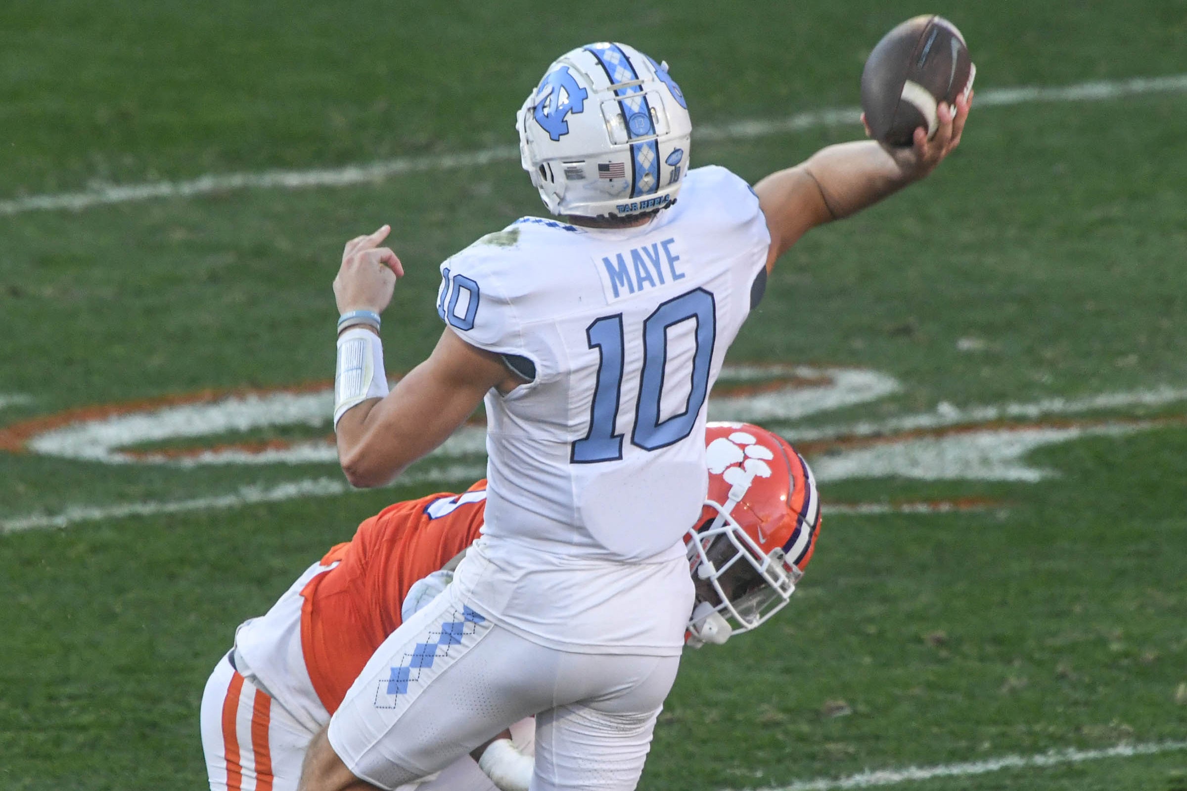 Nov 18, 2023; Clemson, South Carolina, USA; North Carolina Tar Heels quarterback Drake Maye (10) throws a pass to wide receiver J.J. Jones (not pictured) for a touchdown against Clemson Tigers defensive tackle Tyler Davis (13) during the first quarter at Memorial Stadium. Mandatory Credit: Ken Ruinard-USA TODAY Sports