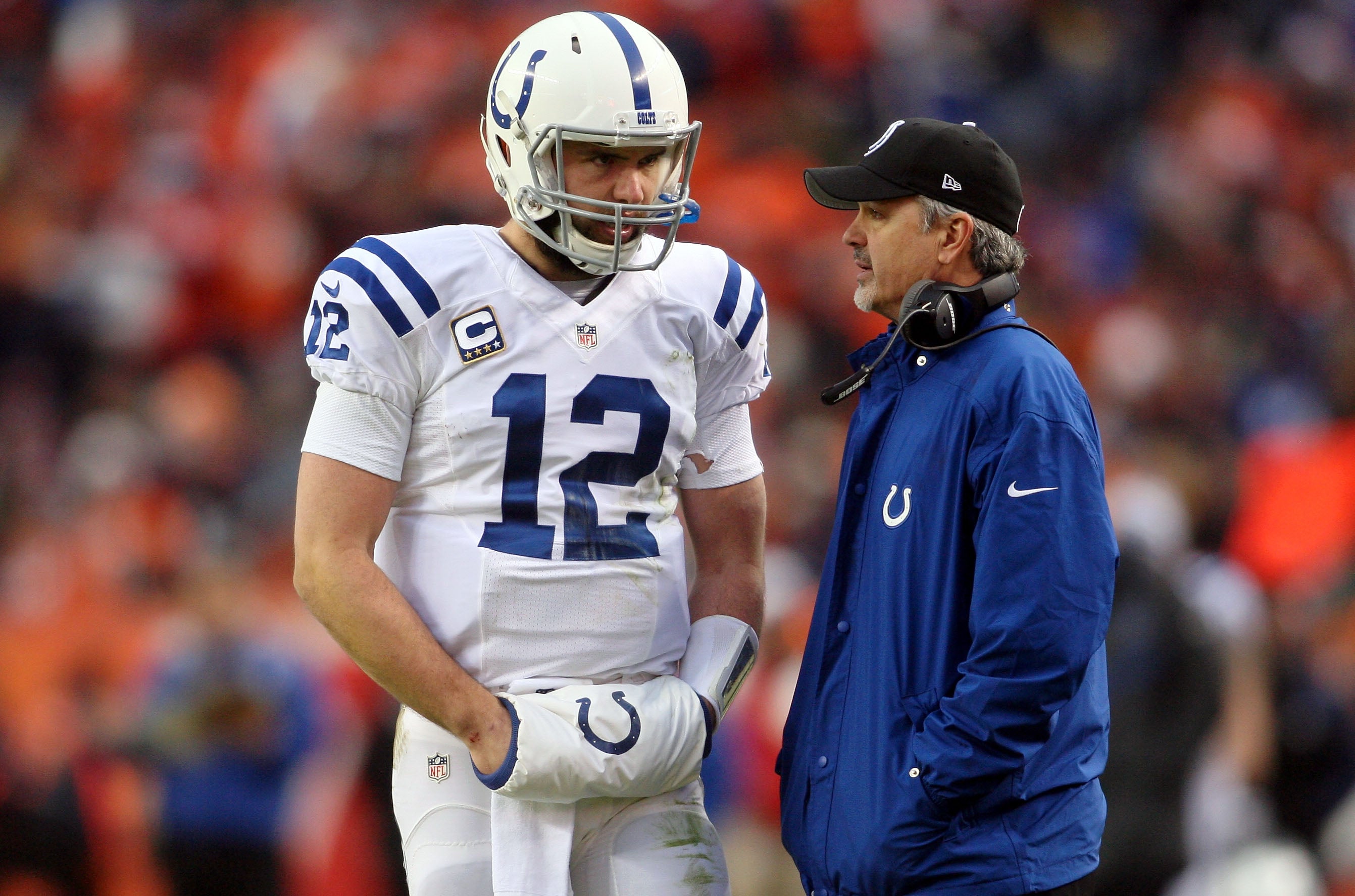 Jan 11, 2015; Denver, CO, USA; Indianapolis Colts quarterback Andrew Luck (12) talks with head coach Chuck Pagano during the second quarter in the 2014 AFC Divisional playoff football game at Sports Authority Field at Mile High.