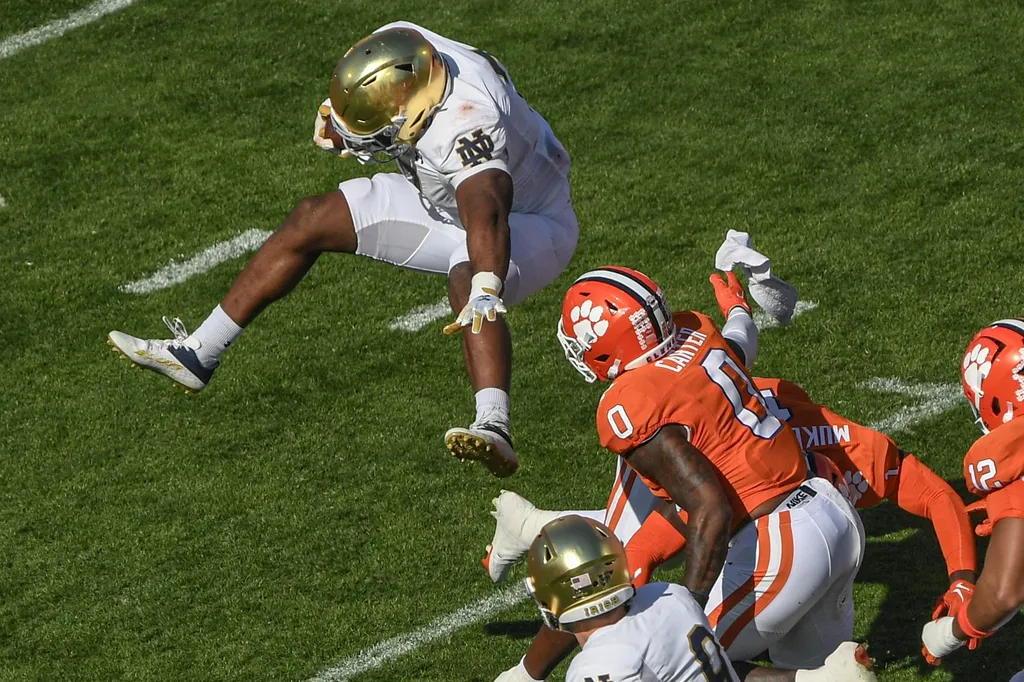 Notre Dame Fighting Irish running back Audric Estime (7) leaps over Clemson Tigers safety Andrew Mukuba (1) during the first quarter at Memorial Stadium.