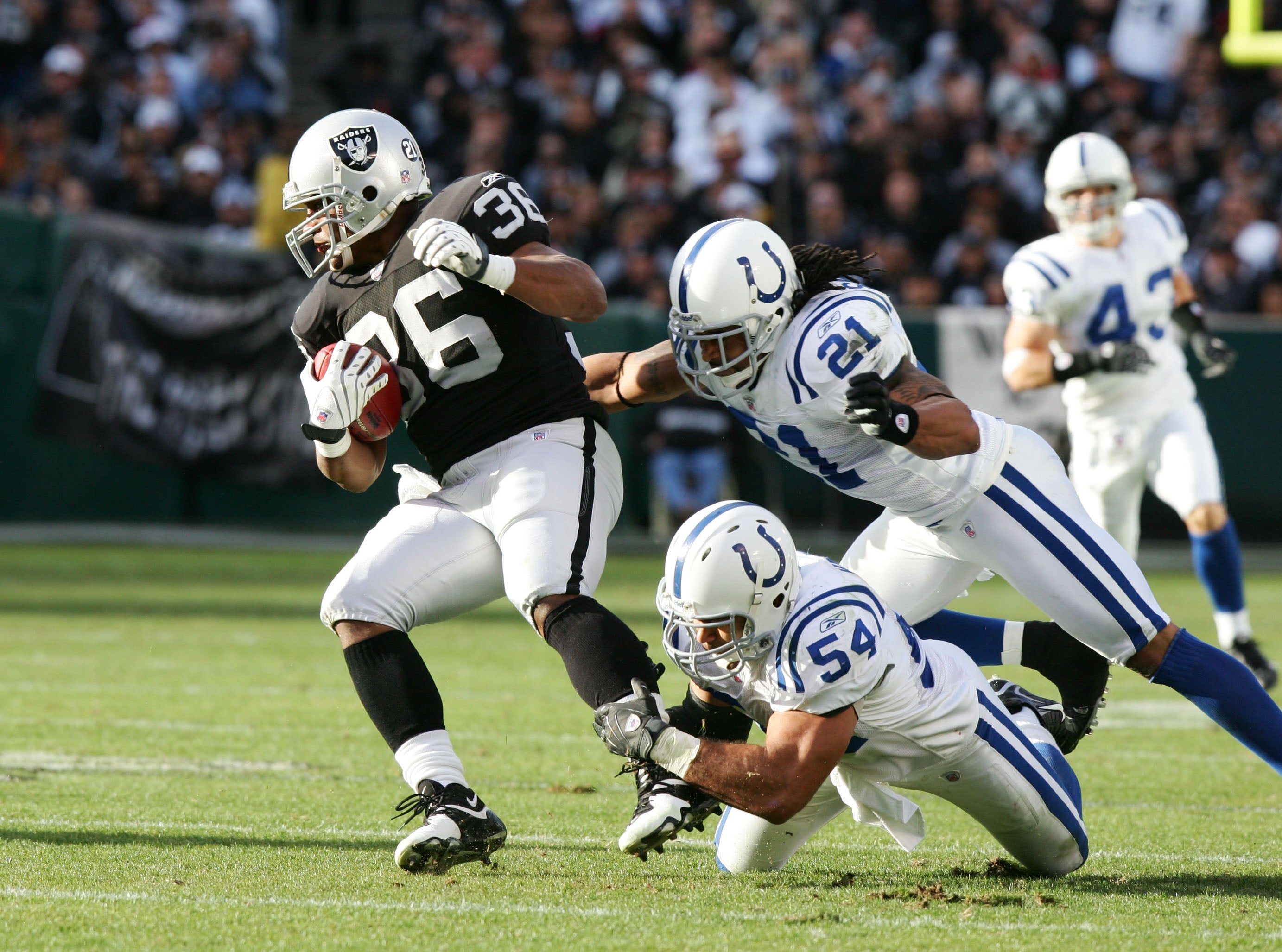 Dec 16, 2007; Oakland, CA, USA; Oakland Raiders FB Justin Griffith (36) is tackled by Indianapolis Colts linebacker Freddie Keiaho (54) and safety Bob Sanders (21) during the third quarter at McAfee Coliseum in Oakland, CA. The Colts defeated the Raiders 21-14.