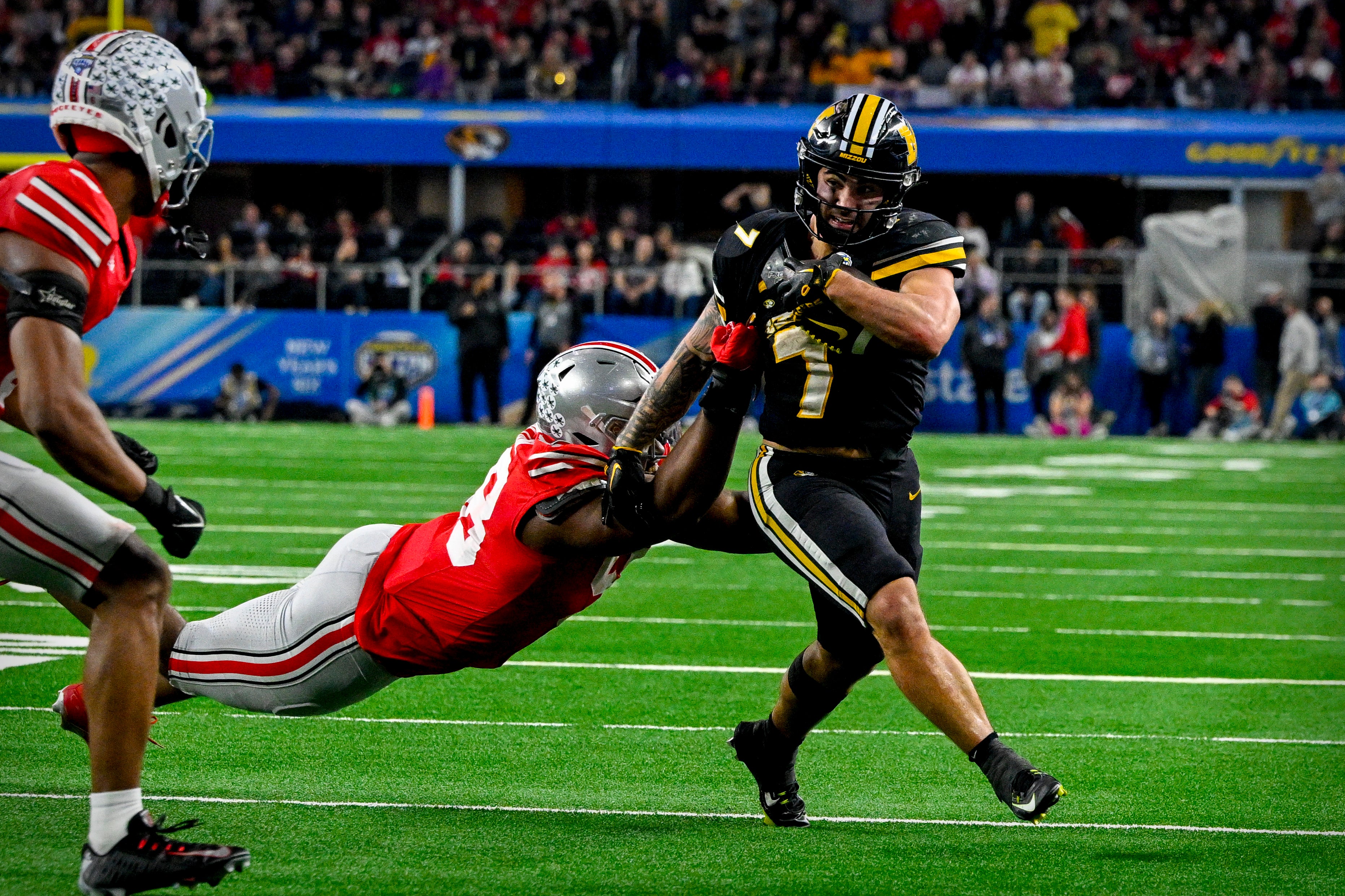 Dec 29, 2023; Arlington, TX, USA; Missouri Tigers running back Cody Schrader (7) runs for a first down against the Ohio State Buckeyes during the fourth quarter at AT&T Stadium.