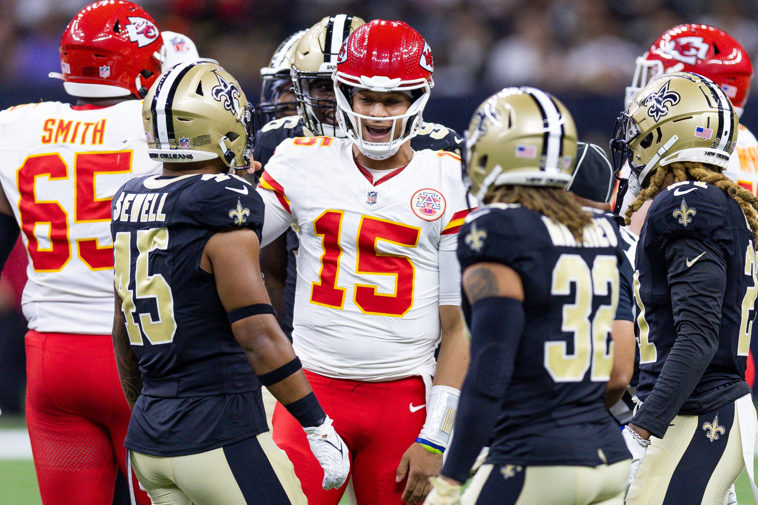 Chiefs quarterback Patrick Mahomes talks to Saints linebacker Nephi Sewell and safety Tyrann Mathieu.