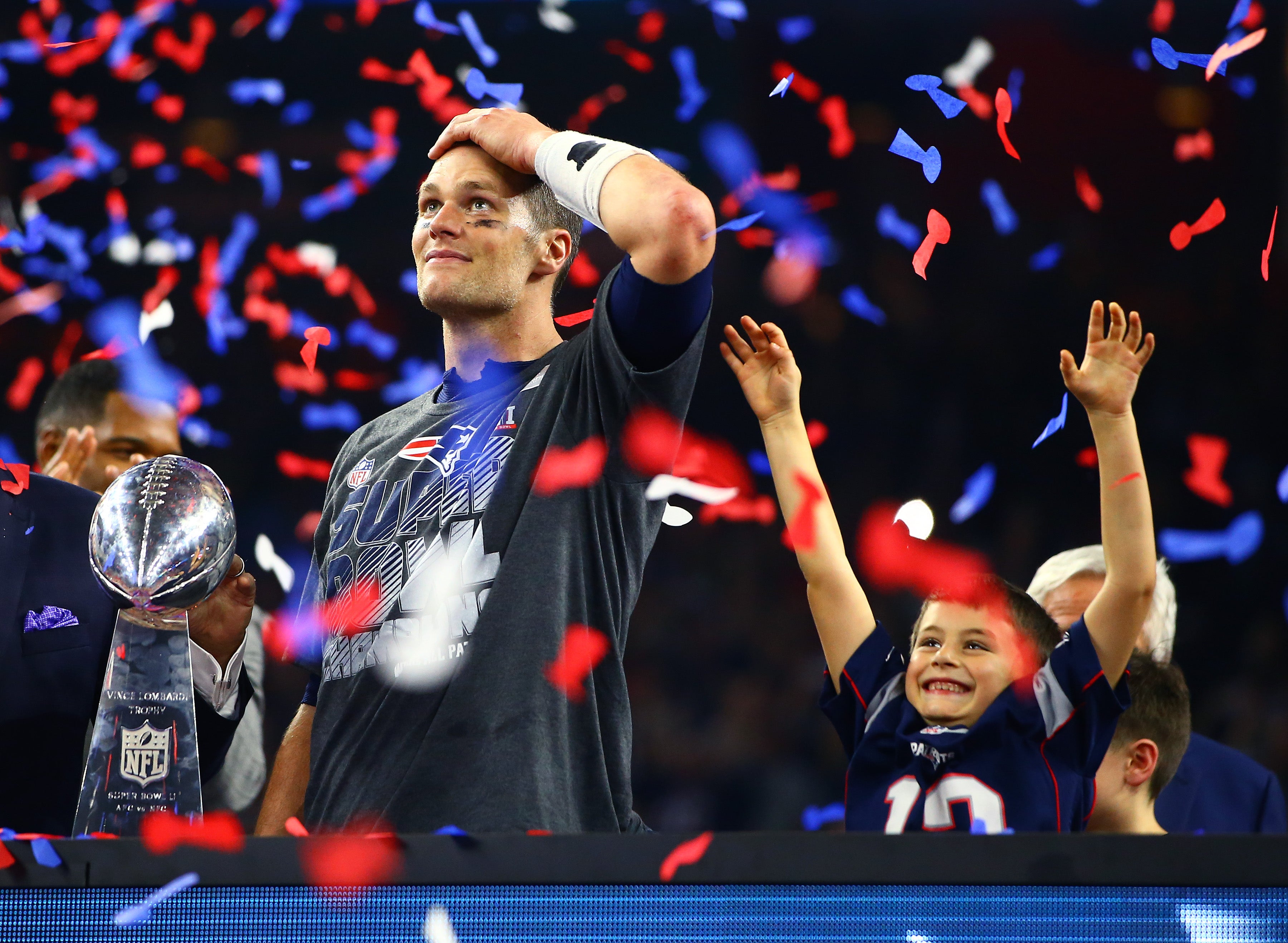Feb 5, 2017; Houston, TX, USA; Confetti falls as New England Patriots quarterback Tom Brady reacts with the Vince Lombardi trophy as his son Benjamin Brady celebrates after defeating the Atlanta Falcons during Super Bowl LI at NRG Stadium.