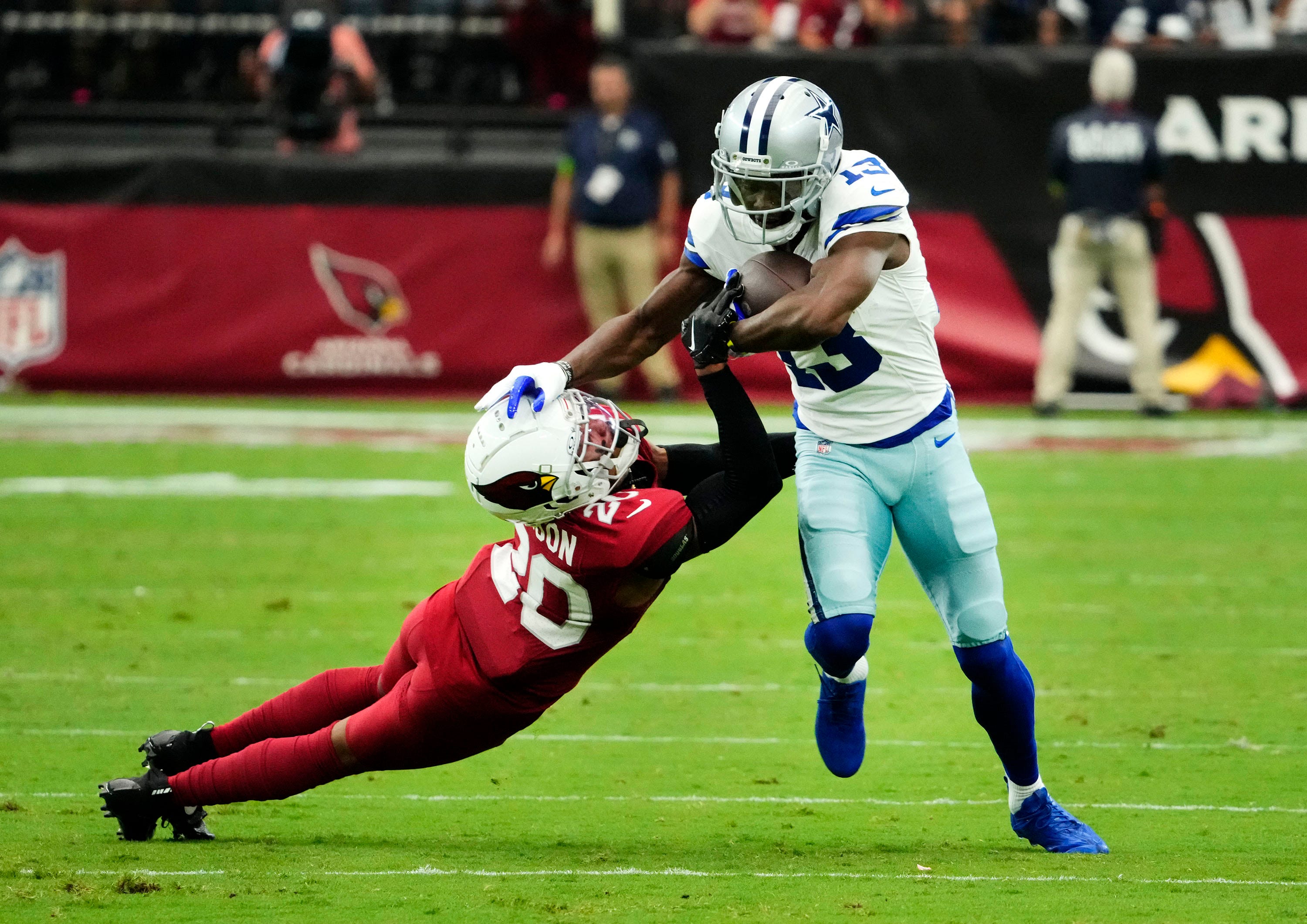 Dallas Cowboys wide receiver Michael Gallup (13) pushes aside Arizona Cardinals cornerback Marco Wilson (20) in the first at State Farm Stadium.