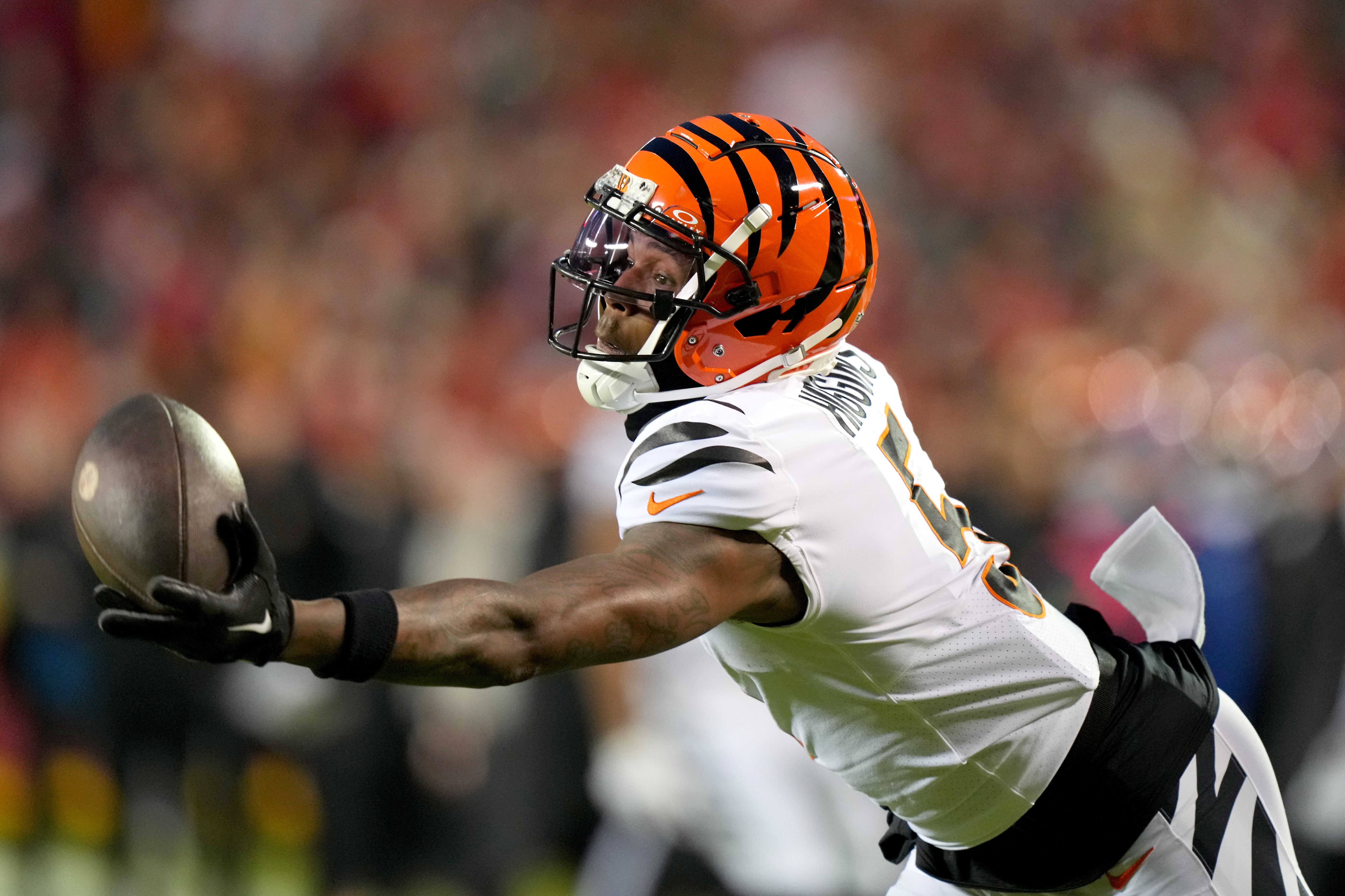 Caption: Dec 31, 2023; Kansas City, Missouri, USA; Cincinnati Bengals wide receiver Tee Higgins (5) gets his hand on a deep pass in the third quarter during a Week 17 NFL football game between the Cincinnati Bengals and the Kansas City Chiefs at GEHA Field at Arrowhead Stadium.