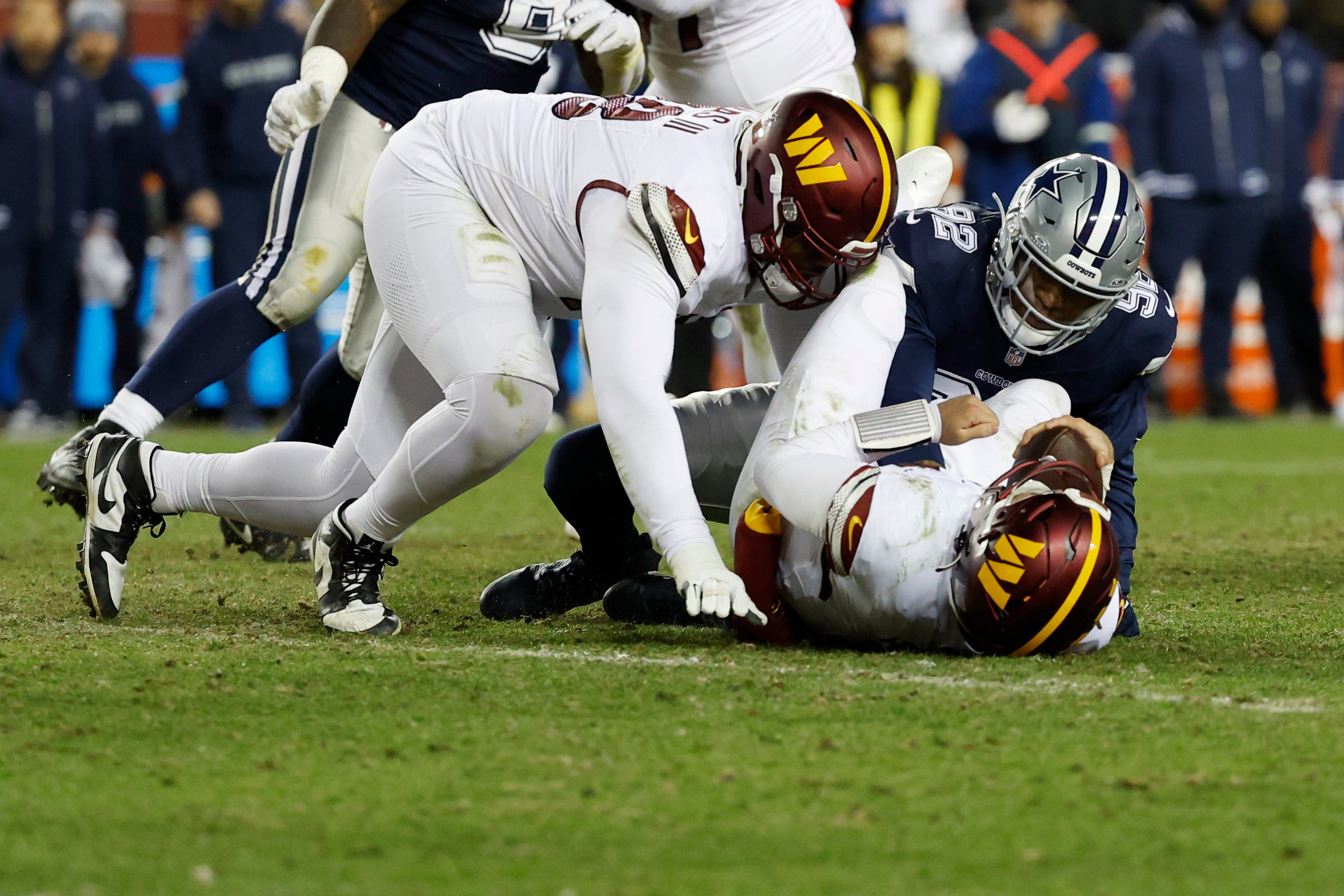 Washington Commanders quarterback Sam Howell (14) is sacked by Dallas Cowboys defensive end Dorance Armstrong (92) during the fourth quarter at FedExField.