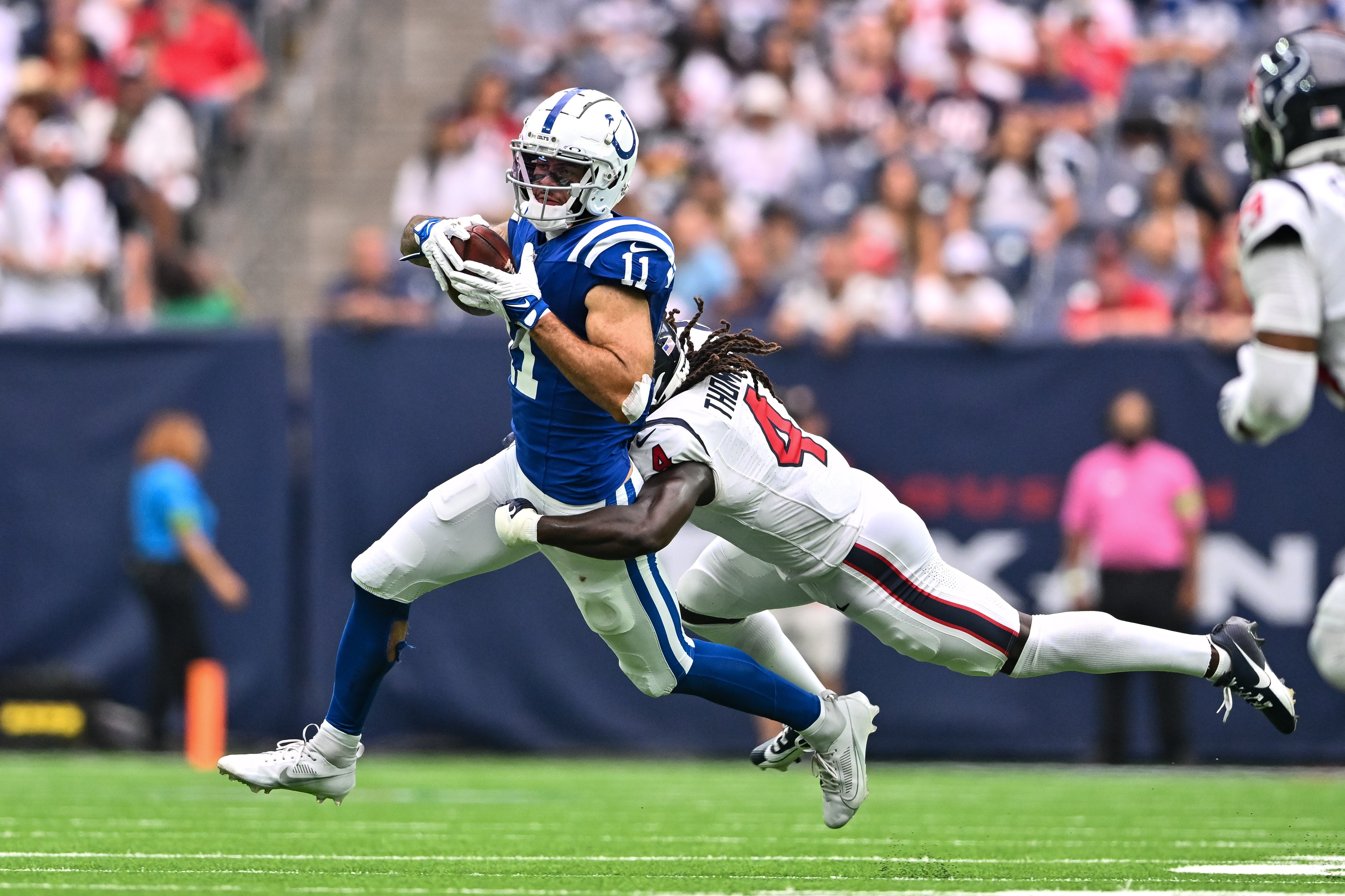 Sep 17, 2023; Houston, Texas, USA; Indianapolis Colts wide receiver Michael Pittman Jr. (11) runs the ball while under pressure from Houston Texans cornerback Tavierre Thomas (4) at NRG Stadium.