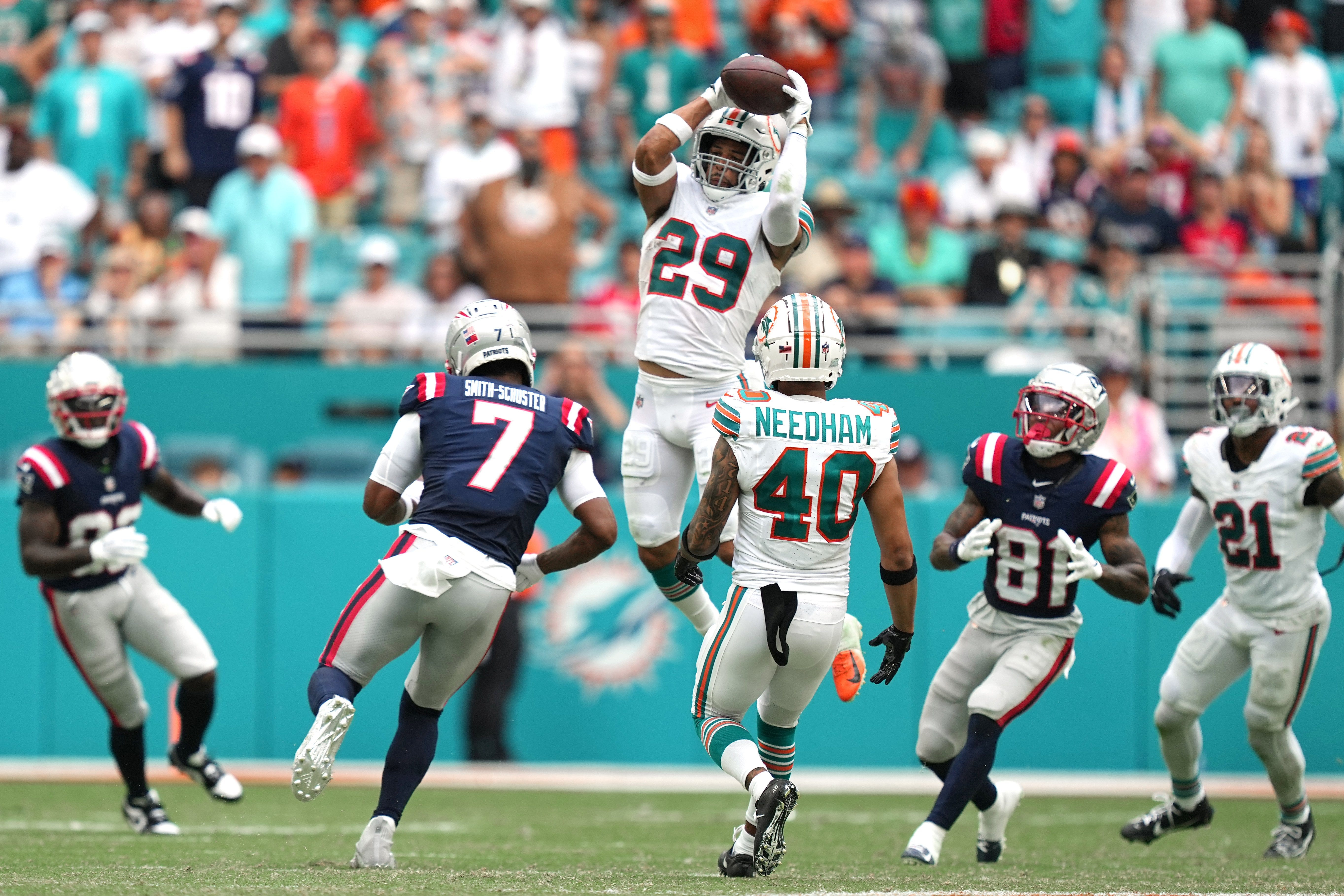 Caption: Miami Dolphins safety Brandon Jones (29) goes up for an interception as New England Patriots wide receiver JuJu Smith-Schuster (7) closes in during the second half of an NFL game at Hard Rock Stadium in Miami Gardens, Oct. 29, 2023.